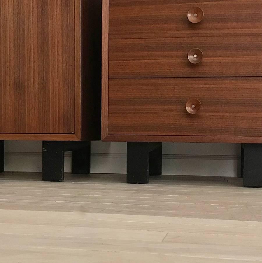 Stunning midcentury walnut cabinets or side tables designed by George Nelson made by Herman Miller. Original cupcake pulls and ebonized legs. Refinished and restored. Sold as the pair only. One piece has four drawers that pull smooth and the other