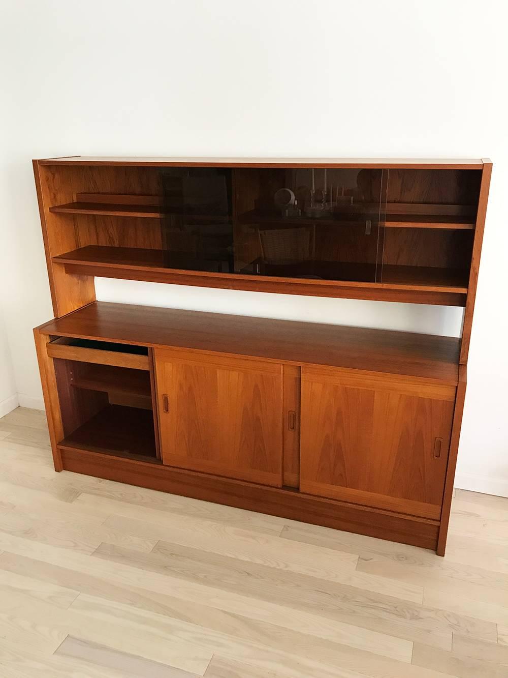 Danish Modern teak sideboard or hutch by Clausen & Son. So much storage with sliding cubbies below and with a felt lined flatware drawer. Pretty wood pulls, rounded teak pulls. Smoked glass sliding hutch doors with hidden back lights. Very clean and