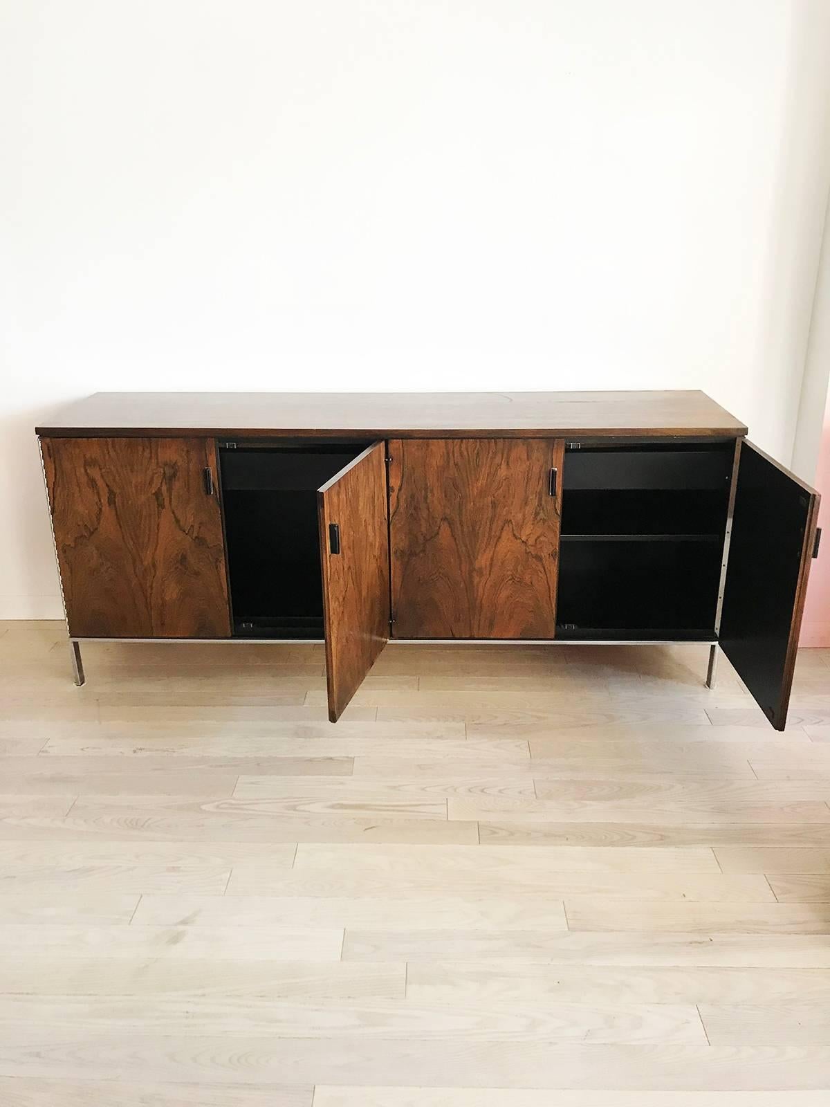 Beautiful rosewood server. Chrome legs. Large and very sturdy. Double cabinets with top drawer and adjustable shelve. Black formica insides. Minor patina on chrome. Beautiful rosewood grain. Some veneer chipping from age at bottom, pictured. Really