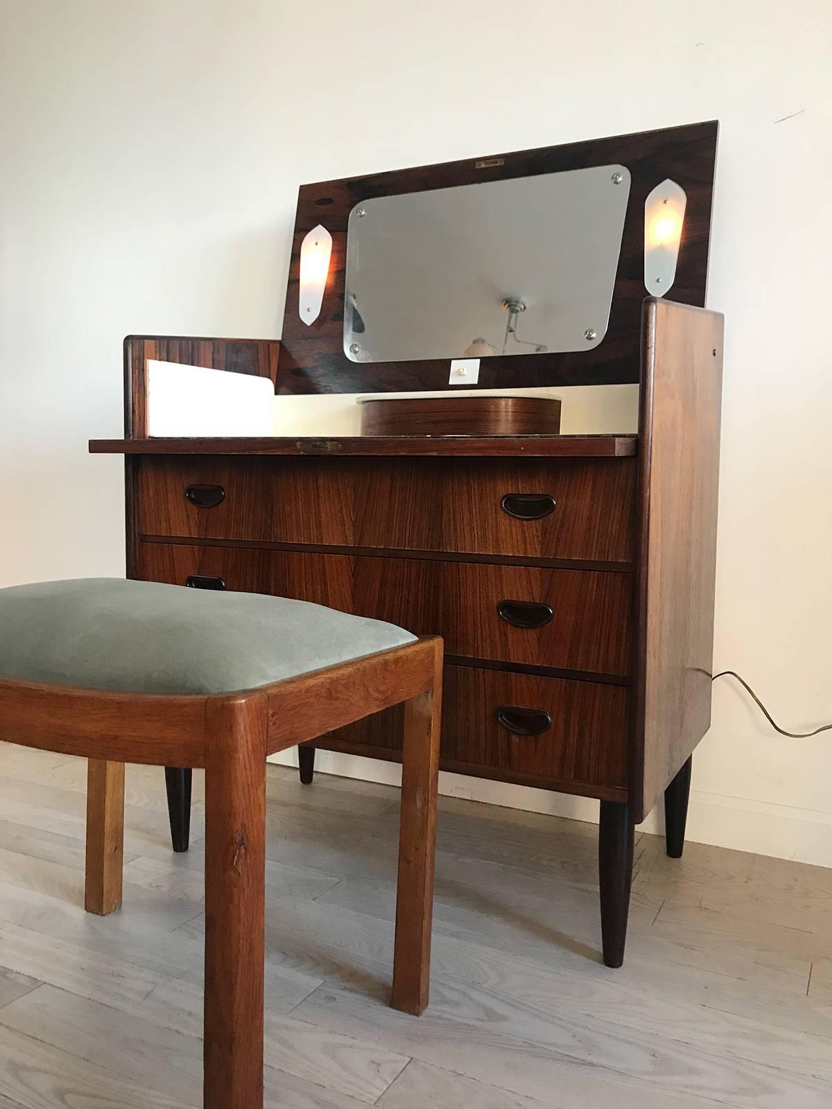 Danish 1960s Brazilian rosewood vanity with a chest of drawers. Flip top with key to lock top section closed. 3 smooth pulling nice drawers with pretty wood pulls. Has storage section on the top and lights, recently rewired for America. Dovetail