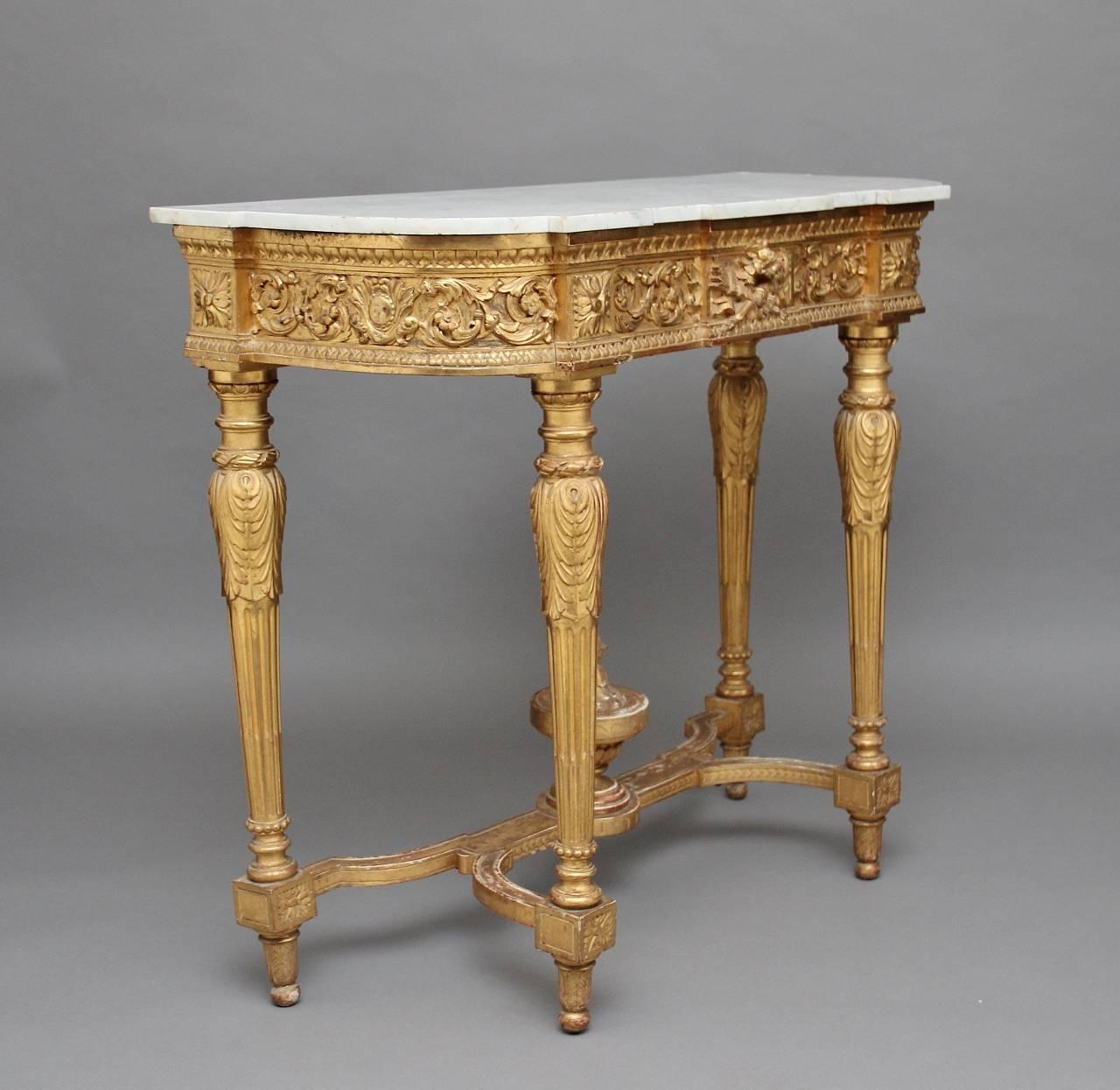 19th century gilt and marble-top console table of good proportions, the shaped white marble-top resting on the frieze which is profusely carved with floral decoration, with four carved and fluted legs supported by a shaped stretcher with a bold