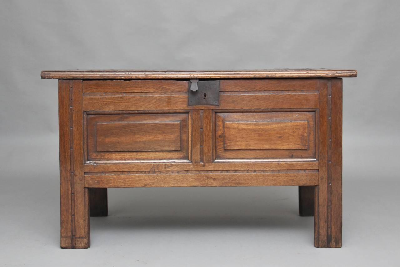 17th century oak coffer with a three panelled hinged lift up top revealing a small compartment inside, the coffer having panelled sides and front, supported on square legs, circa 1680.