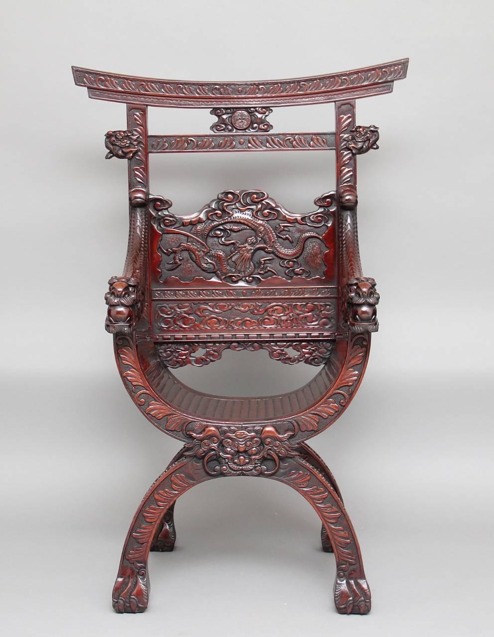 19th century Chinese throne / armchair profusely carved all-over, the back panel decorated with a carved dragon and carved fret work below, with carved dragon arms united onto a curved seat, supported on a cross frame base standing on paw feet,
