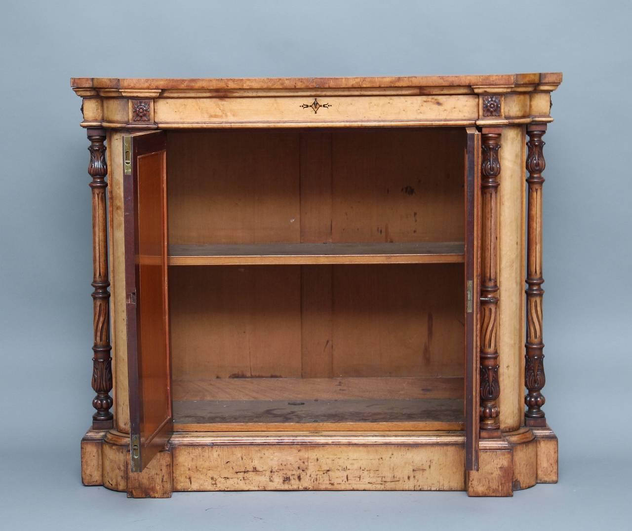 An unusual and rare 19th century bird's eye maple cabinet, with a lovely shaped top with a frieze drawer below with carved patraes either side, the two door cupboard with satinwood panels opening to reveal a single shelf inside, with twin turned and