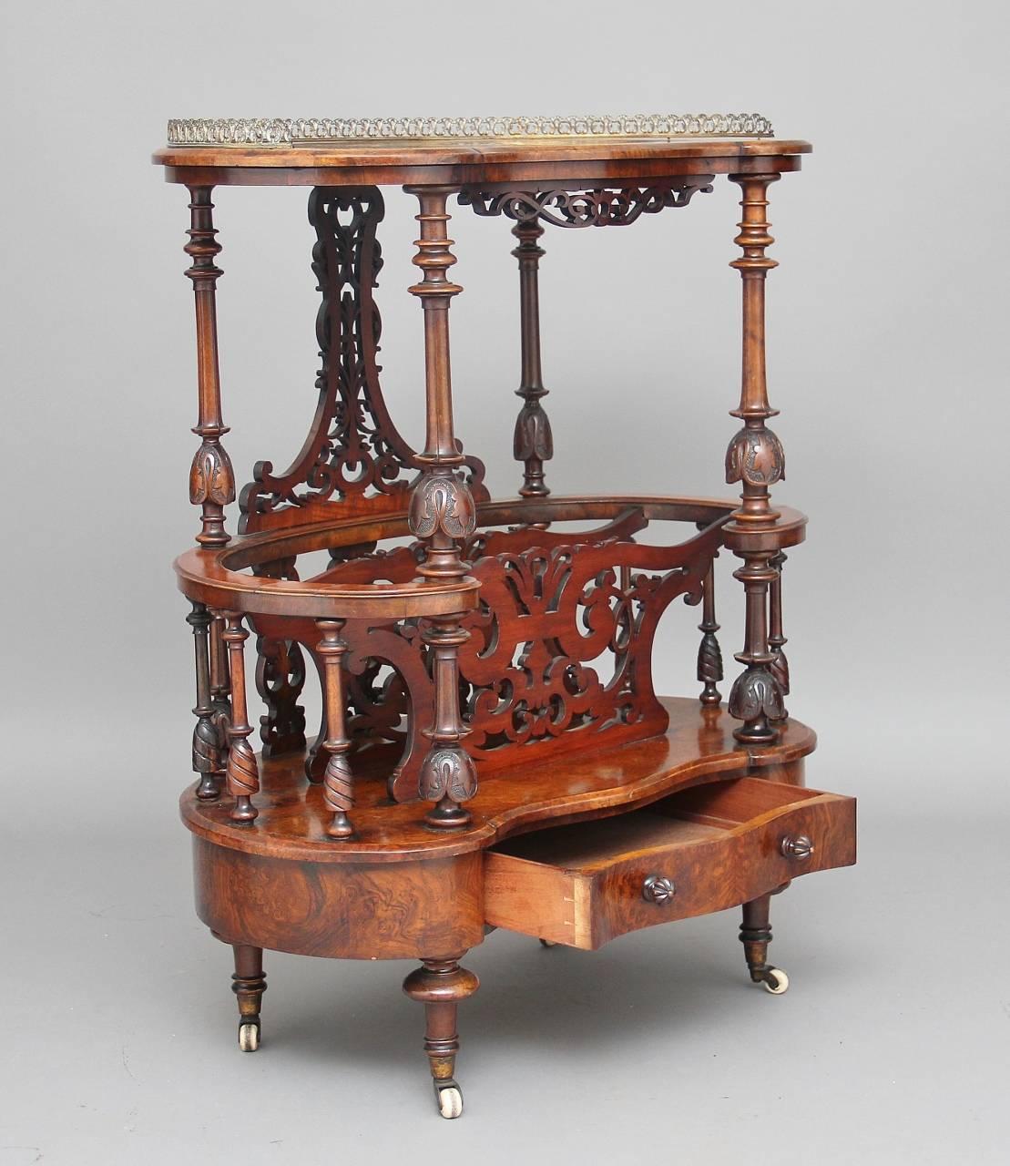 19th century burr walnut canterbury, the kidney shaped top inlaid with boxwood lines and floral decoration, with a pierced brass gallery running along the top, raised on four turned and finely carved columns with the back having a lovely shaped