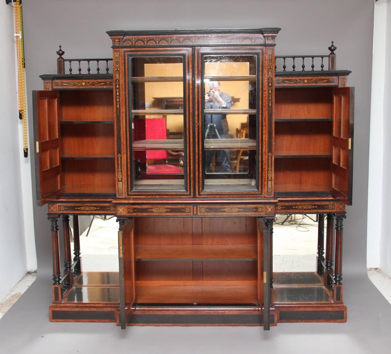 19th century Victorian aesthetic movement, of exhibition quality, ebony and burr yew wood display cabinet, made by James Lamb of Manchester, profusely inlaid with boxwood, the top section with two glazed doors in the middle with a mirror back inside