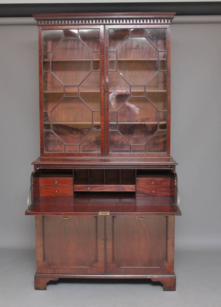 18th century mahogany secretaire bookcase with a nice moulded cornice with dentil moulding, the bookcase having two astrigal glazed doors with three adjustable shelves inside, the bottom section having a pull-out secretaire drawer opening to reveal