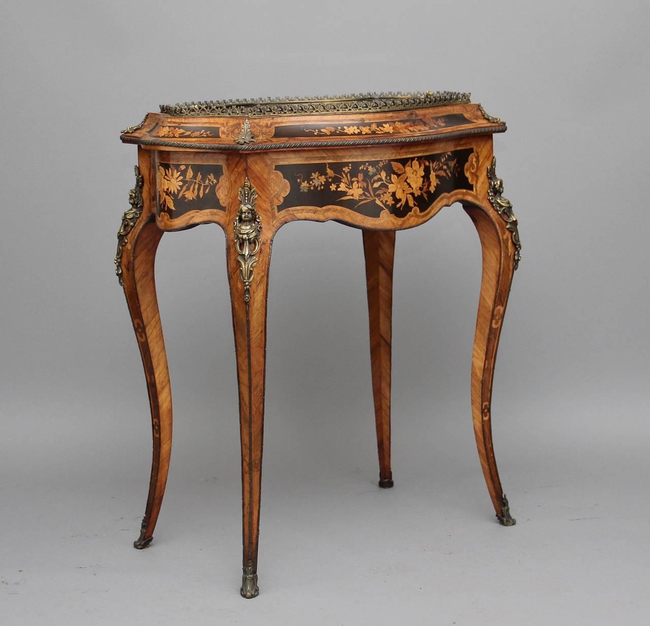 19th century French kingwood and inlaid bijouterie table with lovely quality gilt mounts, with a brass gallery mount surrounding a removable glass panel top enclosing a lined interior, having a shaped apron on all sides decorated with floral