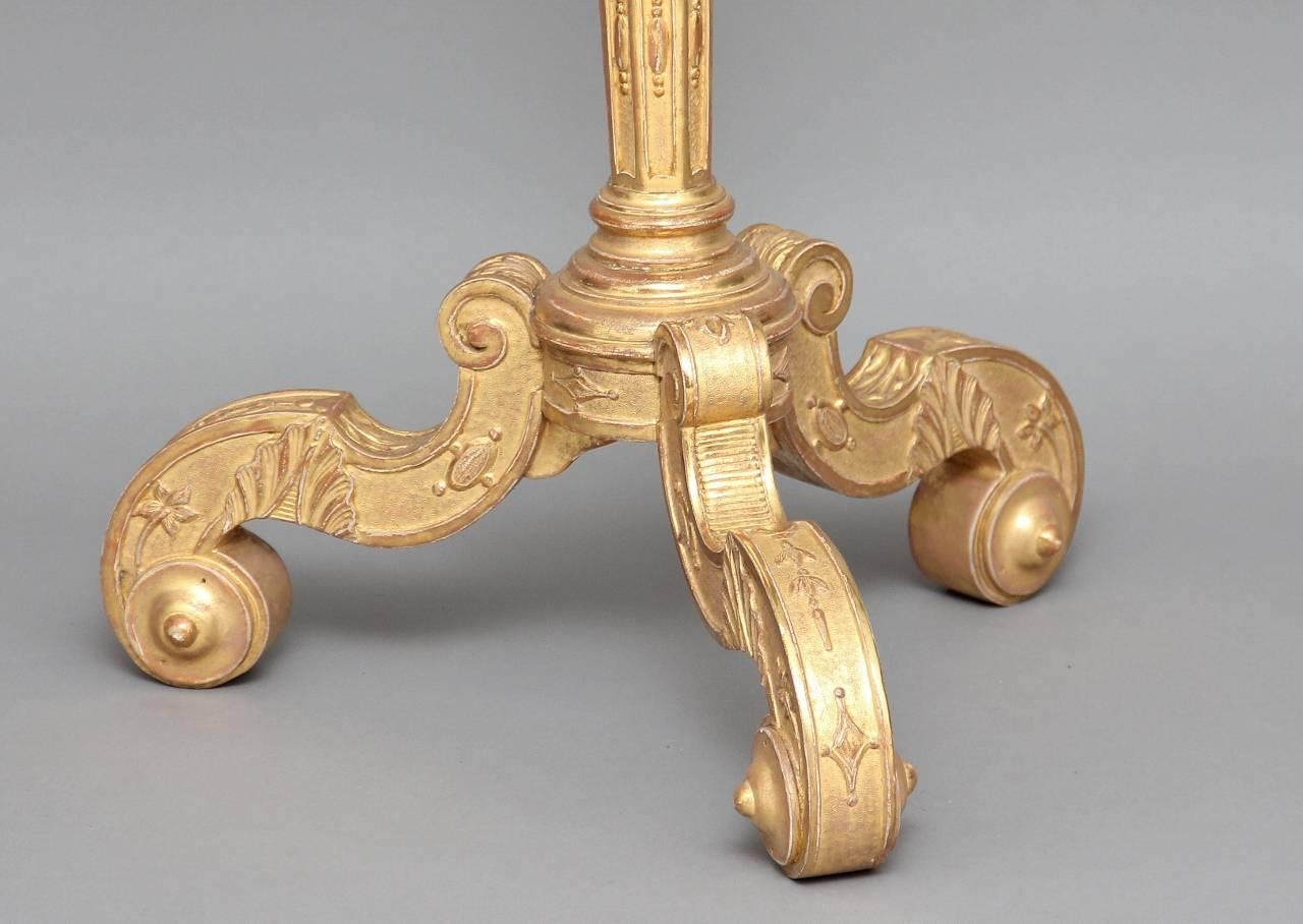An early 19th century decorative highly carved and gilded torcher, the top profusely carved with an ornate column raised on three nicely shaped feet, circa 1820.