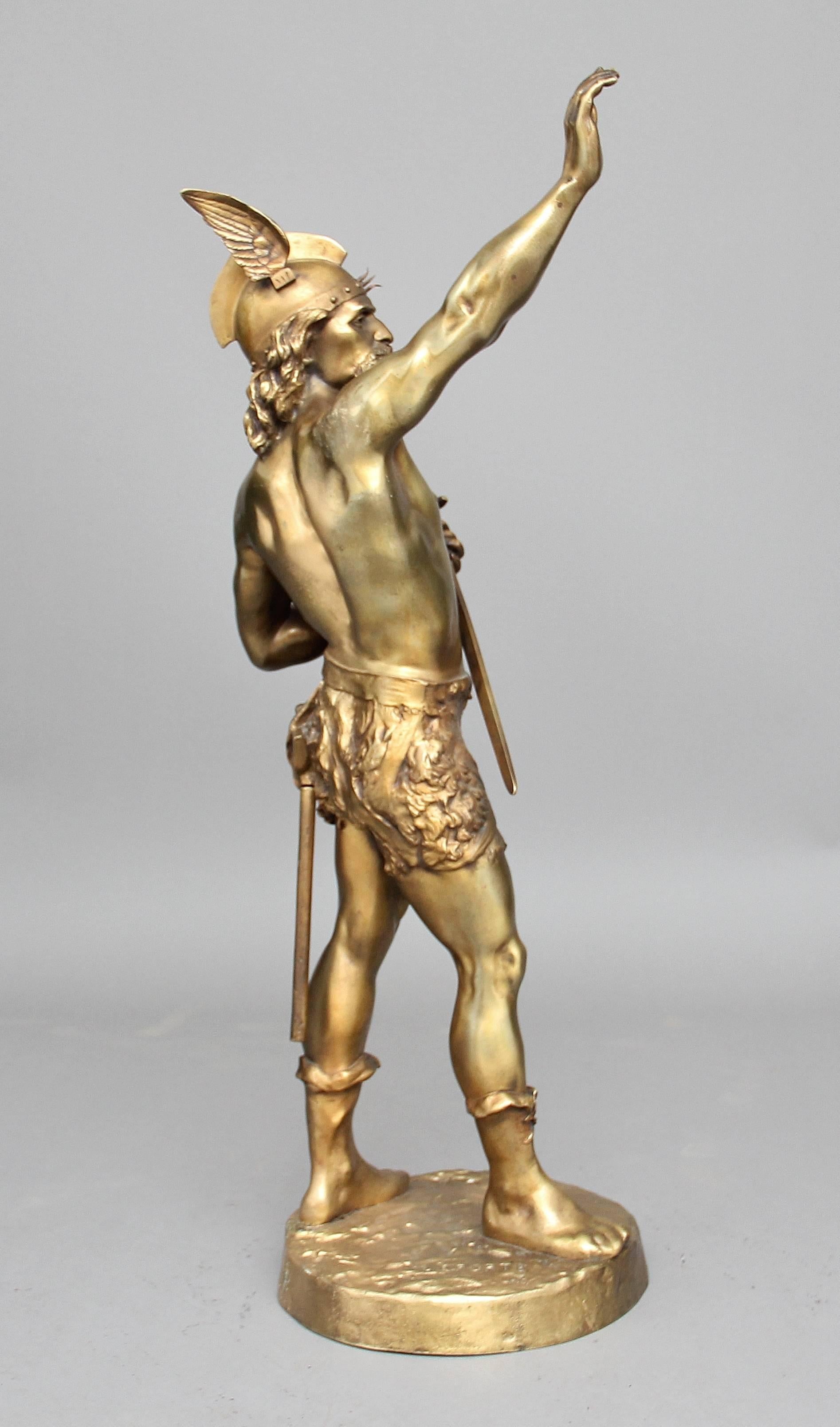A large 19th century gilt bronze figure of a Viking warrior by the French artist Emile Laporte (1858 – 1907), the warrior standing on a circular plinth with his right arm raised whilst holding a sword in his left hand, the circular plinth signed