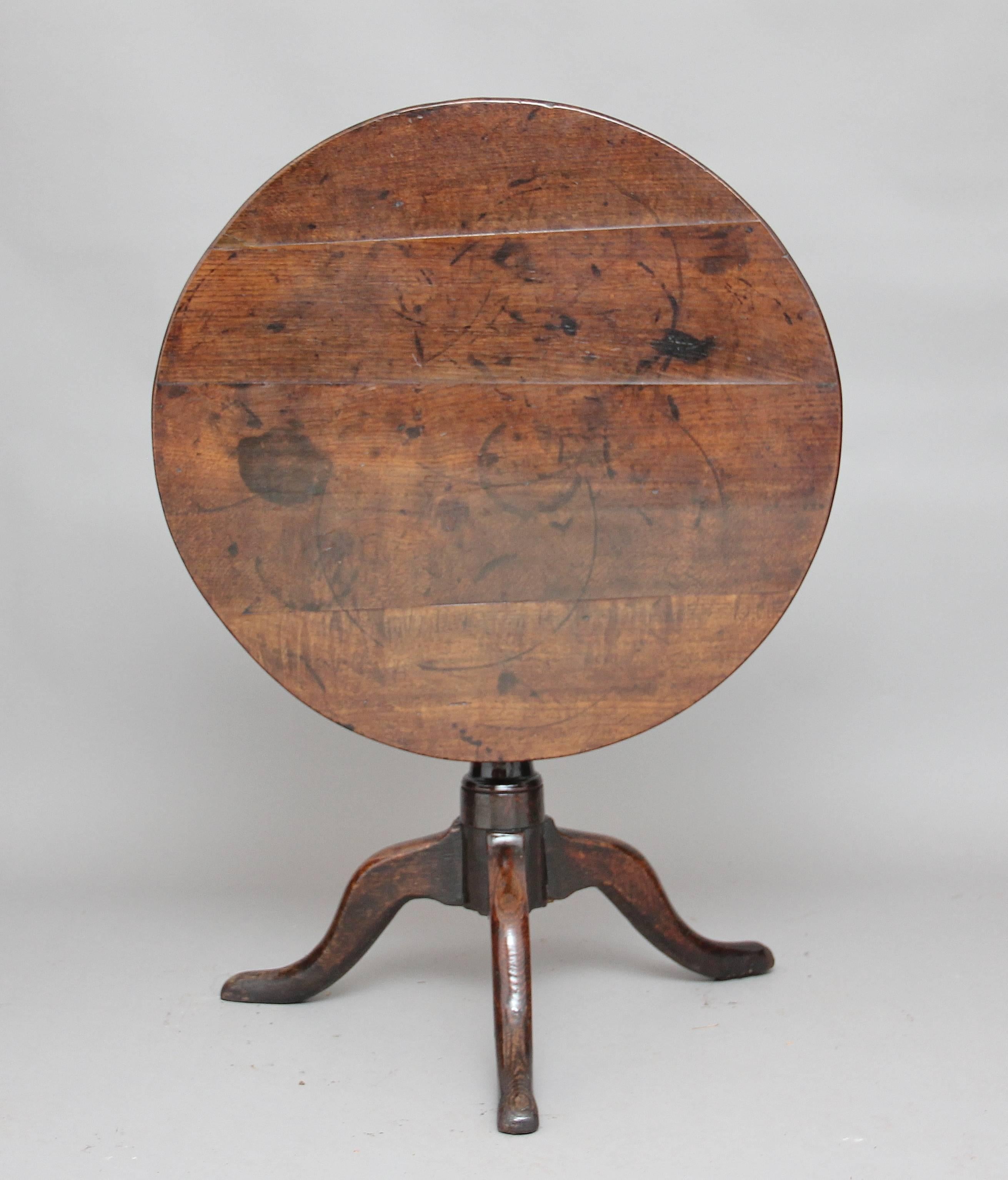 18th century oak tripod table with a planked top supported by a turned column standing on three shaped legs with pad feet, circa 1780.