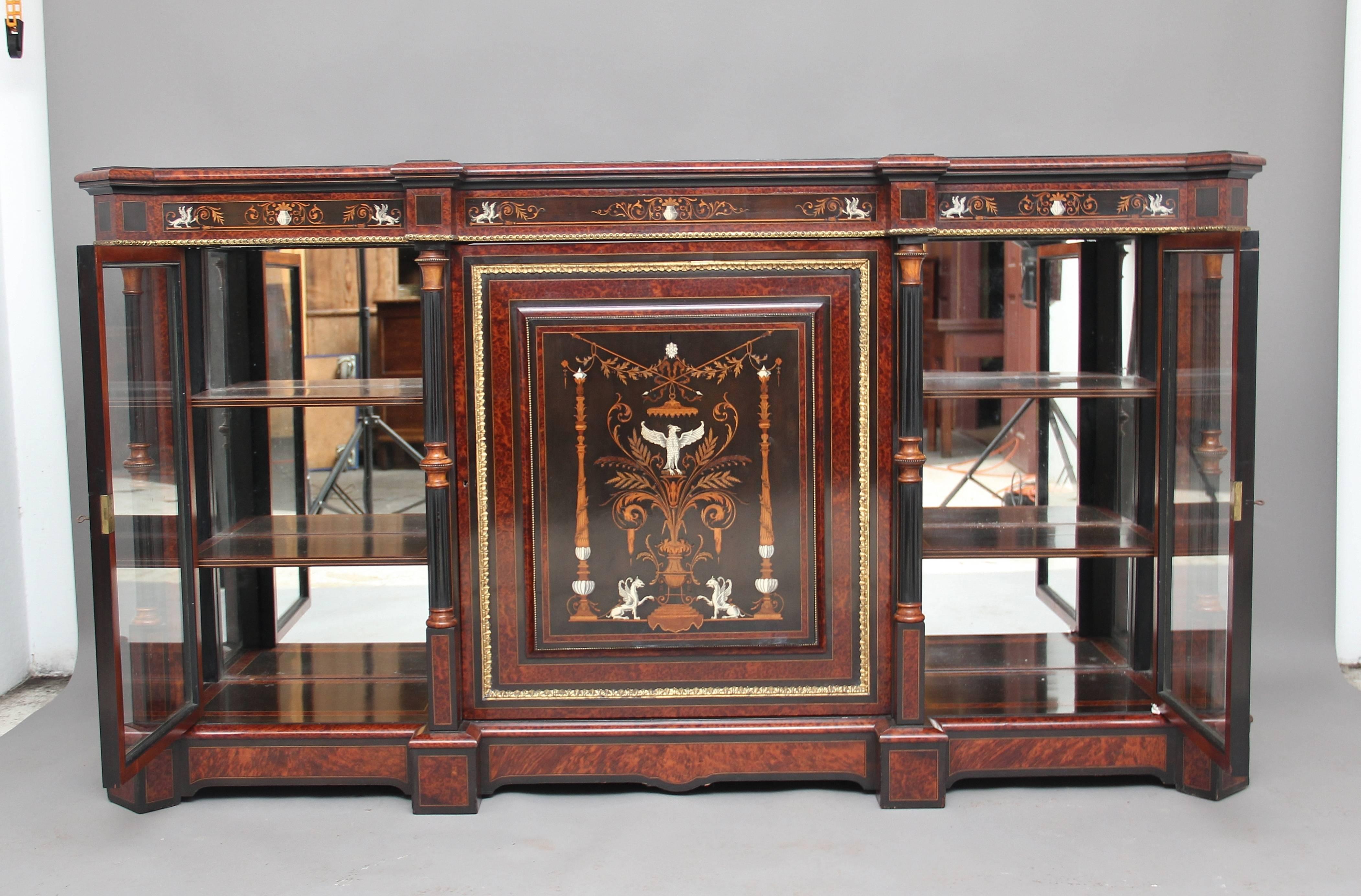 An exhibition quality 19th century amboyna and ebonized cabinet, the wonderfully shaped and detailed top above a profusely inlaid frieze where the inlay is of the highest quality, decorated with ormolu beading which also is running round the central