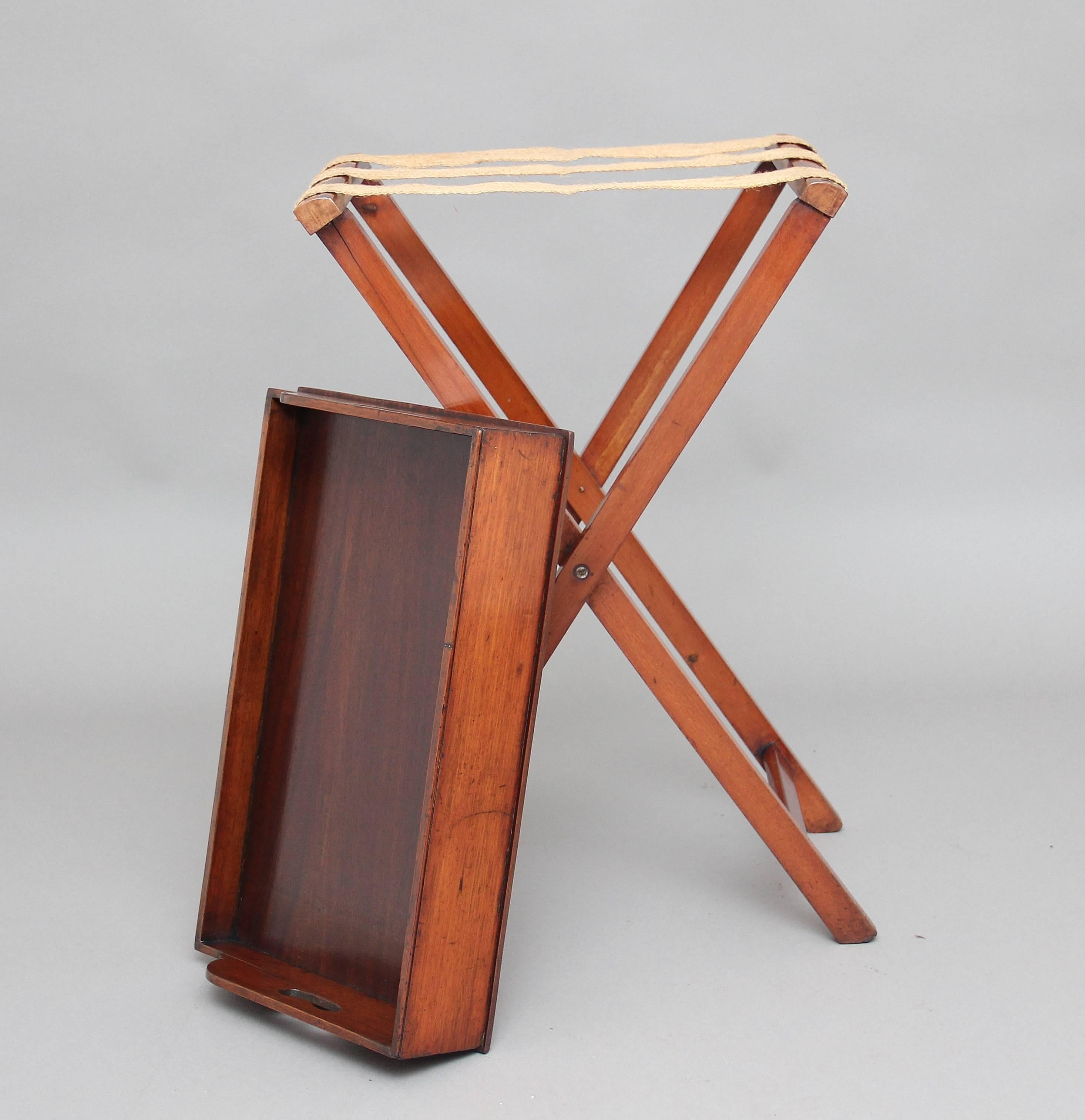 19th century mahogany butlers tray on stand, the rectangular shaped tray with a surround gallery three quarters raised and with two fret cut carrying handles above a folding stand, circa 1880.
     