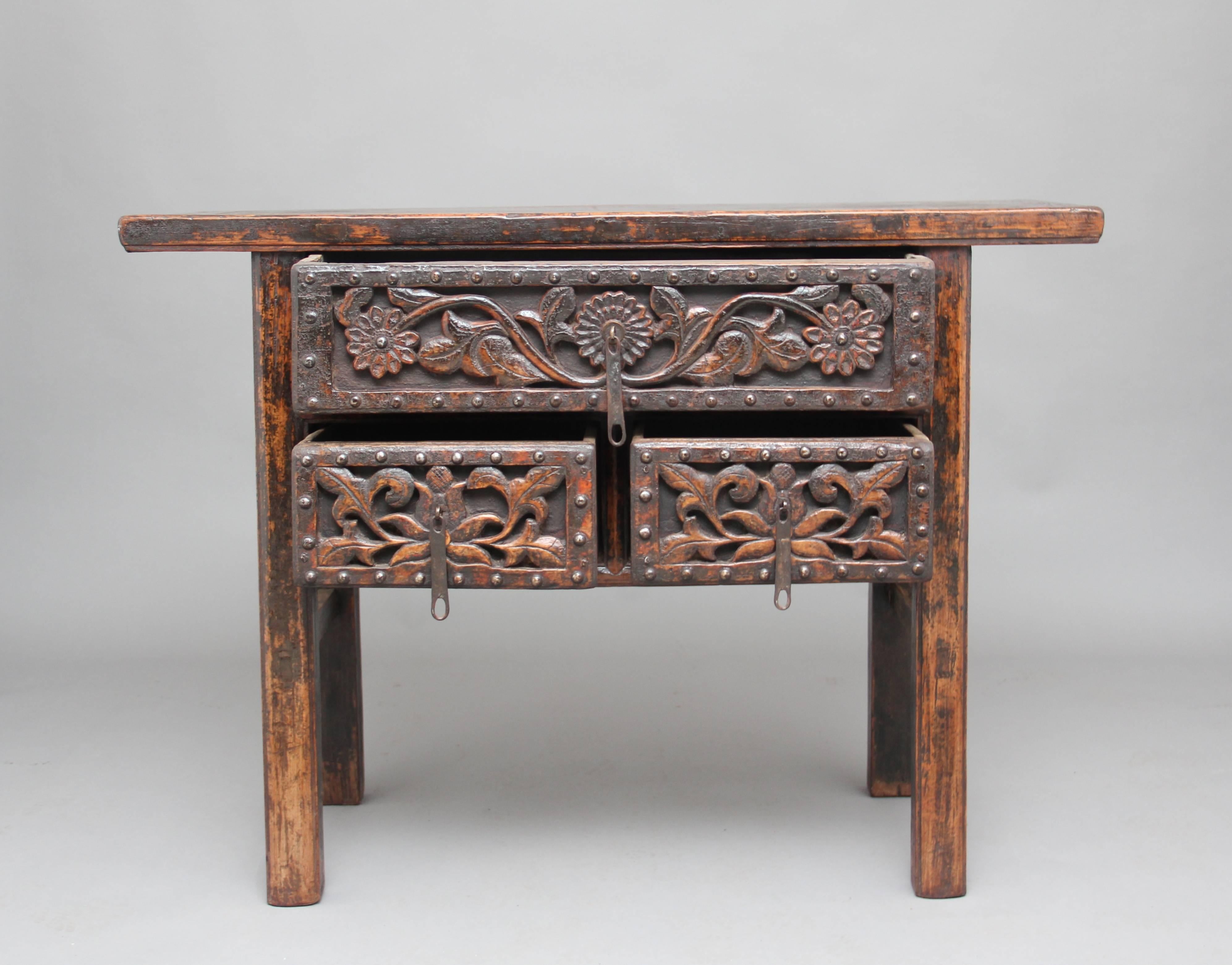 19th century Chinese rustic elm dresser with one long over two short drawers, with the drawer fronts having a carved floral design and original brass hardware, standing on square legs supported with side stretchers, circa 1880.
   