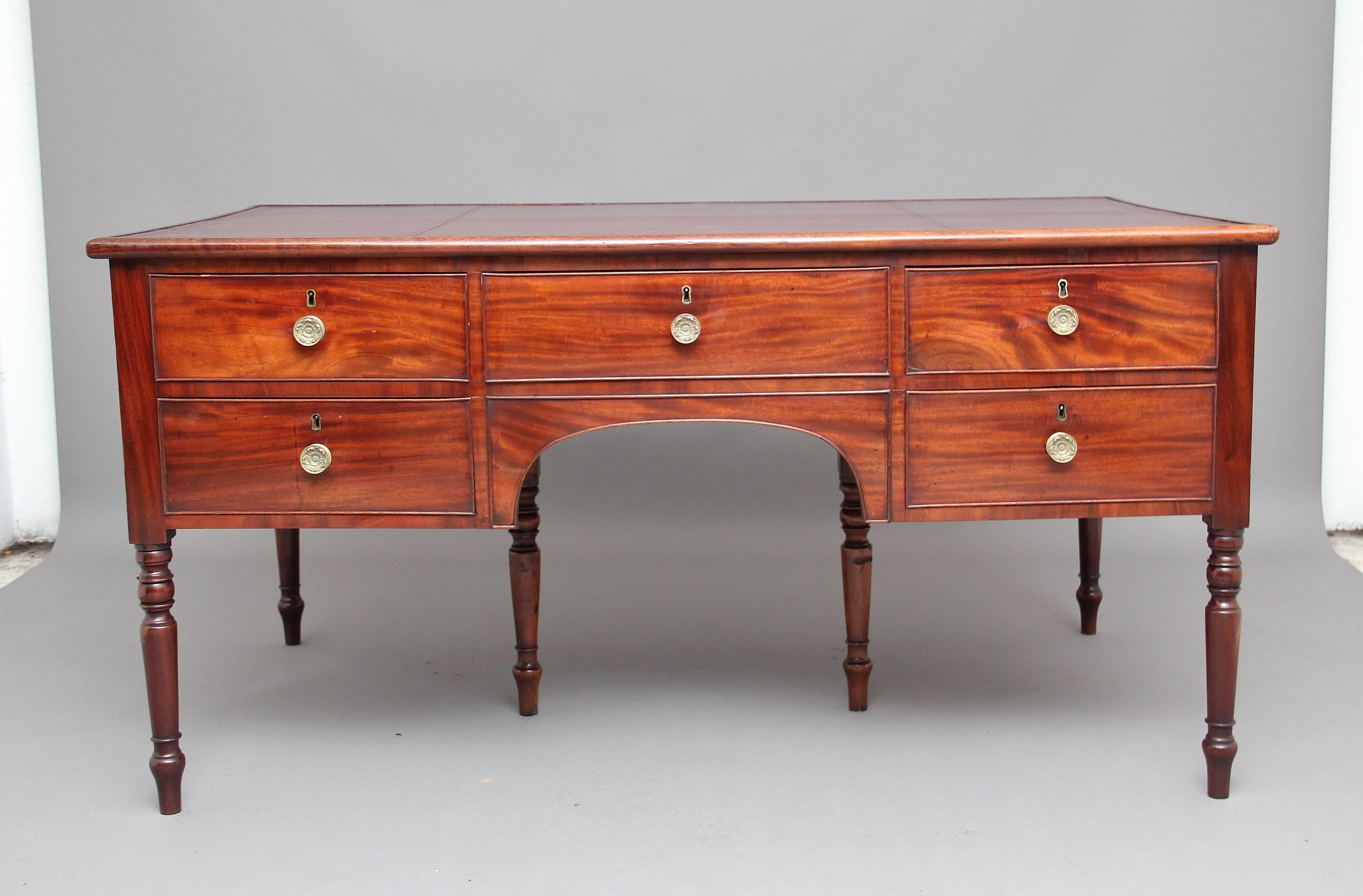 19th century mahogany partners writing desk, with a tooled burgundy leather inset top, the desk having an arrangement of nine drawers, five at the front and four at the back, each drawer having brass turned knob handles, both sides of the desk