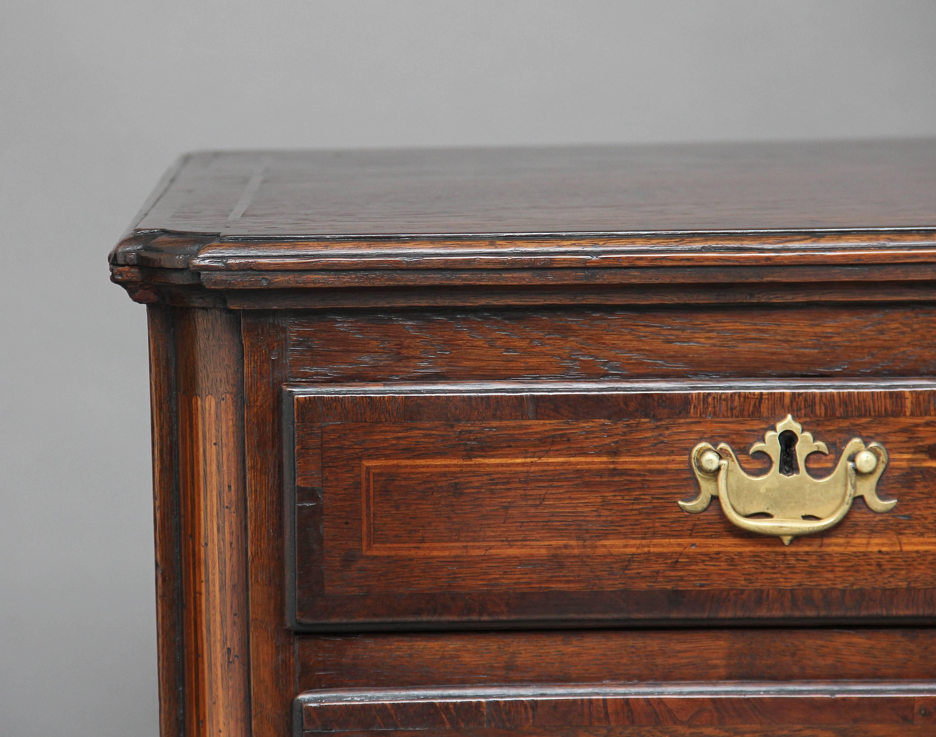 Cassettone in quercia del XVIII secolo a cinque cassetti, due corti e tre lunghi, con fasce incrociate in Oak e intarsi in legno di bosso e maniglie e scudi originali in ottone, con quarti di colonna agli angoli che scendono fino ai piedi, il piano