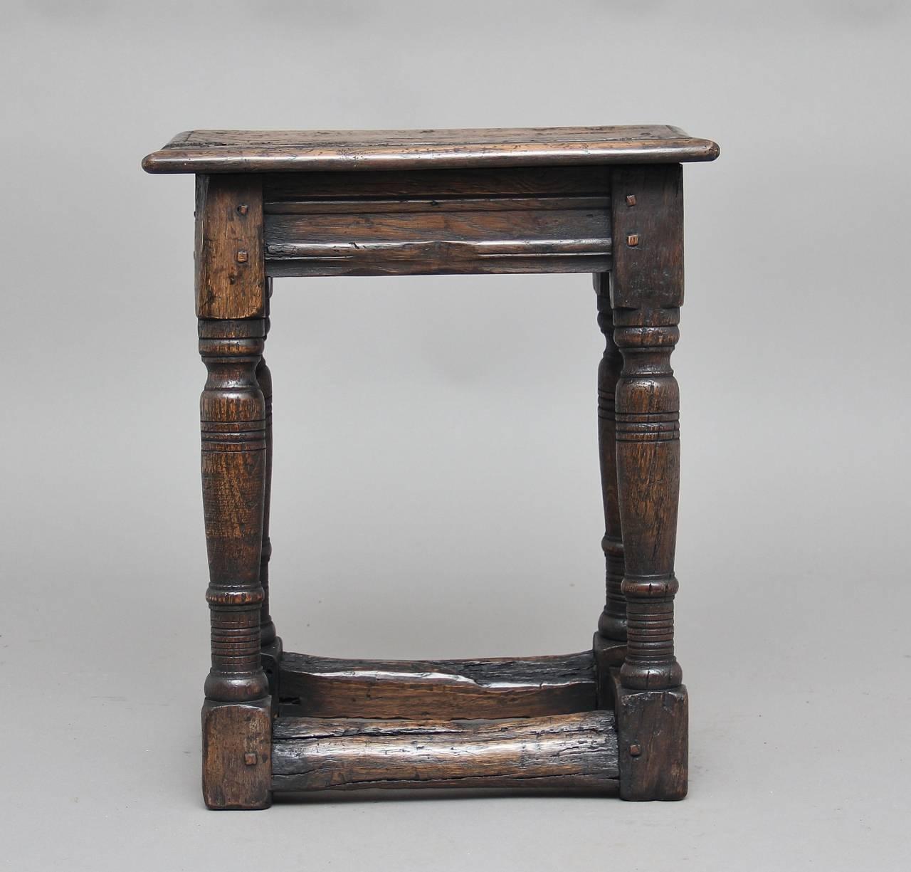 Early 20th century rustic oak joint stool in the 17th century style, the rectangular top raised on turned baluster supports united stretchers, circa 1920.
    