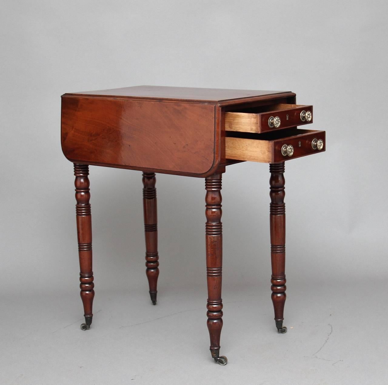 19th century mahogany drop-leaf or side table, the moulded edge top which extends to 28 1/2” (73cms), with two graduated oak lined drawers below with decorative brass turned knobs, the reverse of the table is exactly the same just with faux drawers,