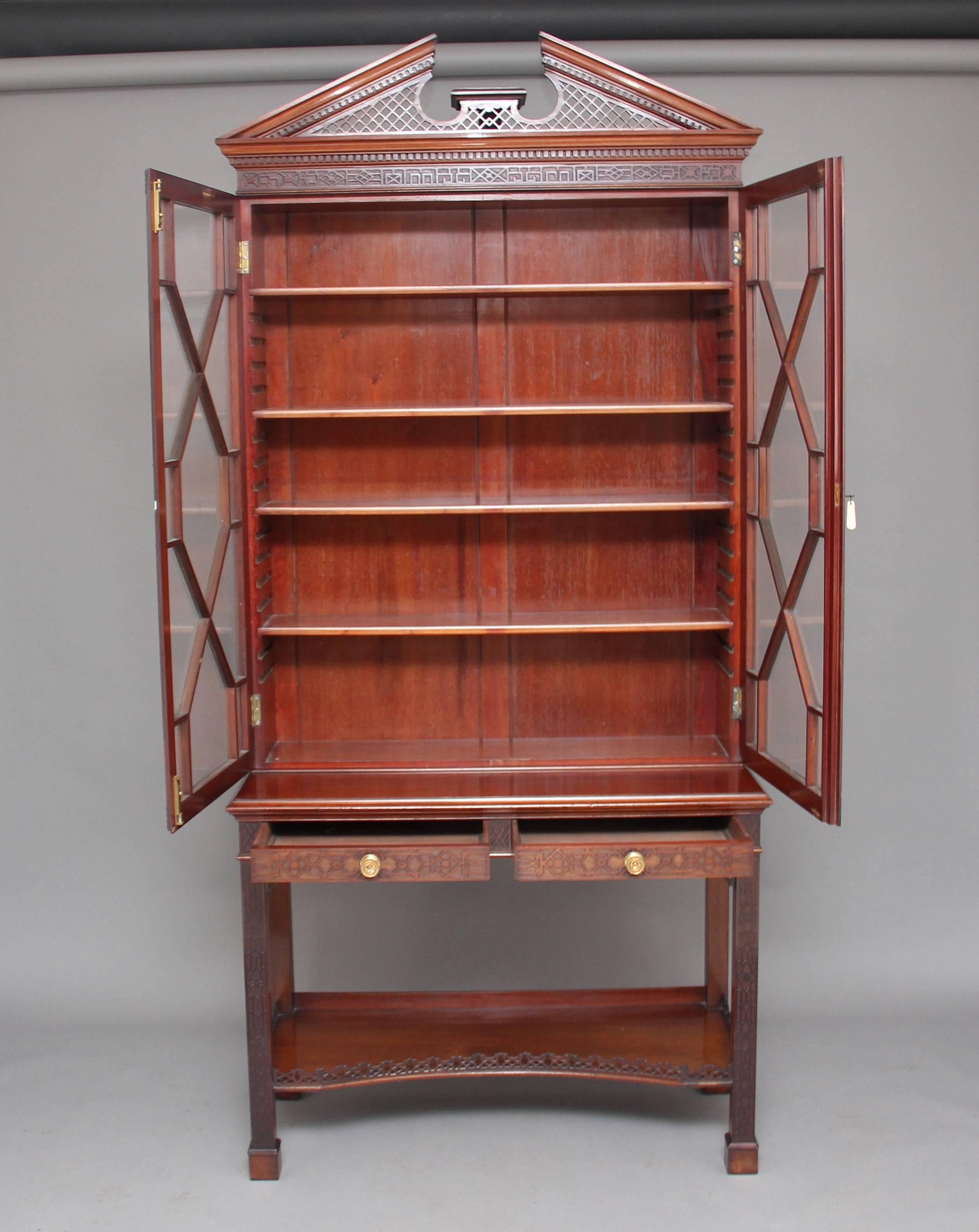 A superb quality early 20th century mahogany cabinet in the Chinese Chippendale manor by Edwards & Roberts, the top of the cabinet has a broken arch pediment with dentil mouldings and pierced fret supports, with the main section profusely decorated