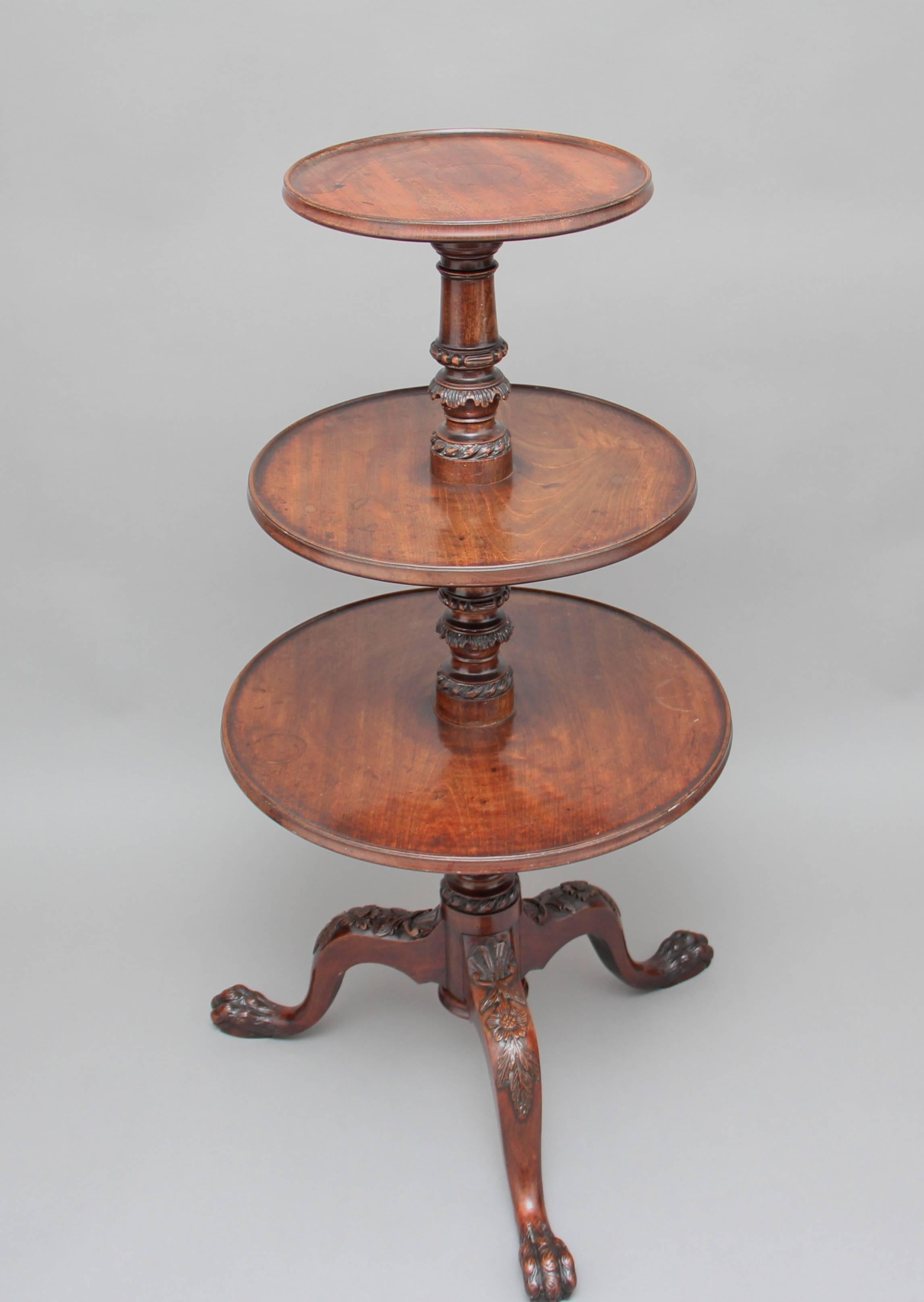 A superb quality early 19th century mahogany three tier dumbwaiter, the wonderfully carved stem supporting three dish tops, standing on three carved cabriole legs ending on a claw foot, circa 1800.