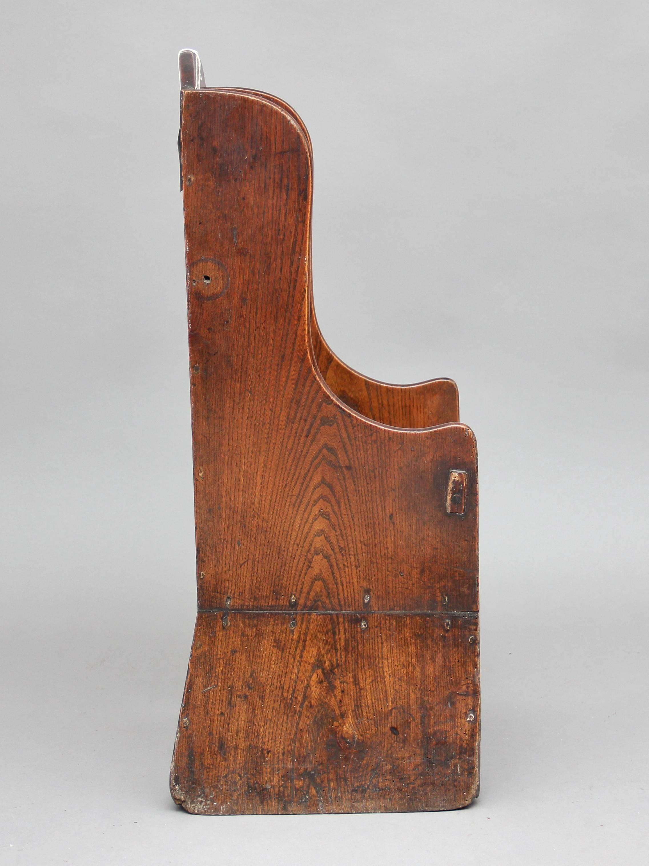 18th century elm upright child’s chair, with shaped sides and an arched back with a pierced hand hold, circa 1780.