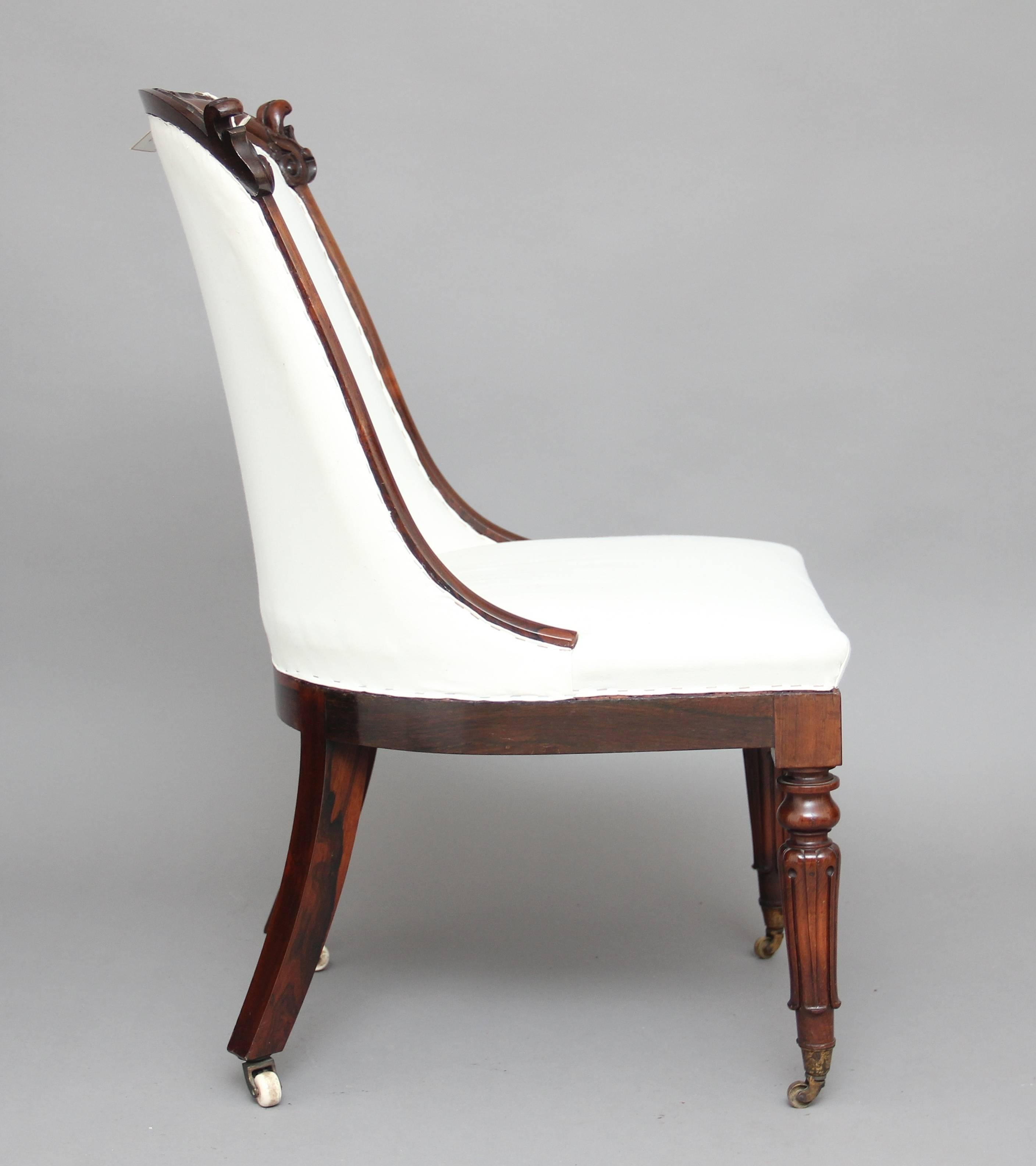 19th century rosewood slipper chair upholstered in a neutral calico, the shaped back having lovely carved detail, the low seat supported on swept back legs and turned and fluted front legs with brass caps and castors. circa 1840.
  