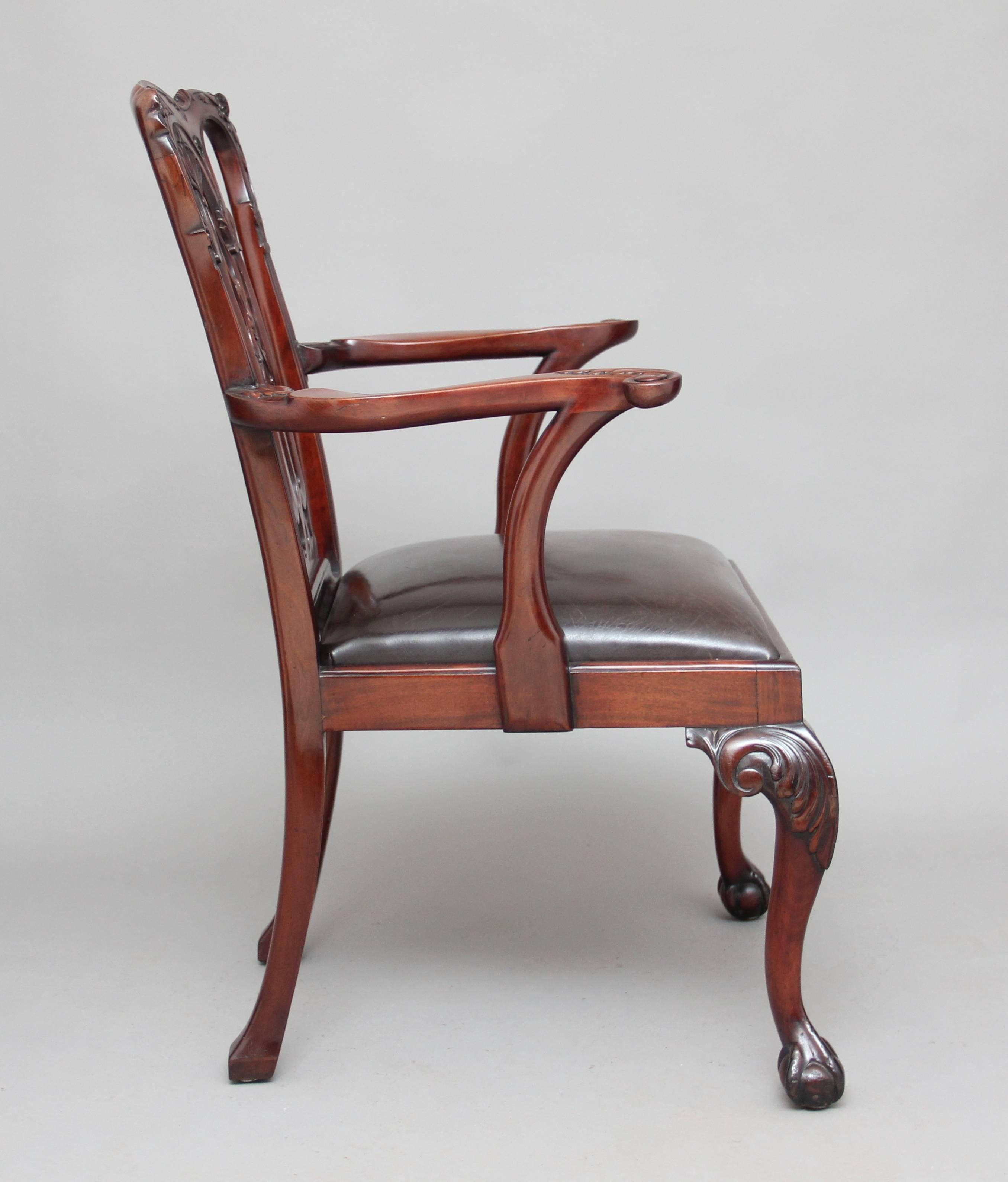 19th century mahogany armchair in the Chippendale style, with a carved and pierced splat in the back, the whole back is also carved as well as the arms, the front cabriole legs are carved on the knees terminating in a ball and claw foot, with a drop