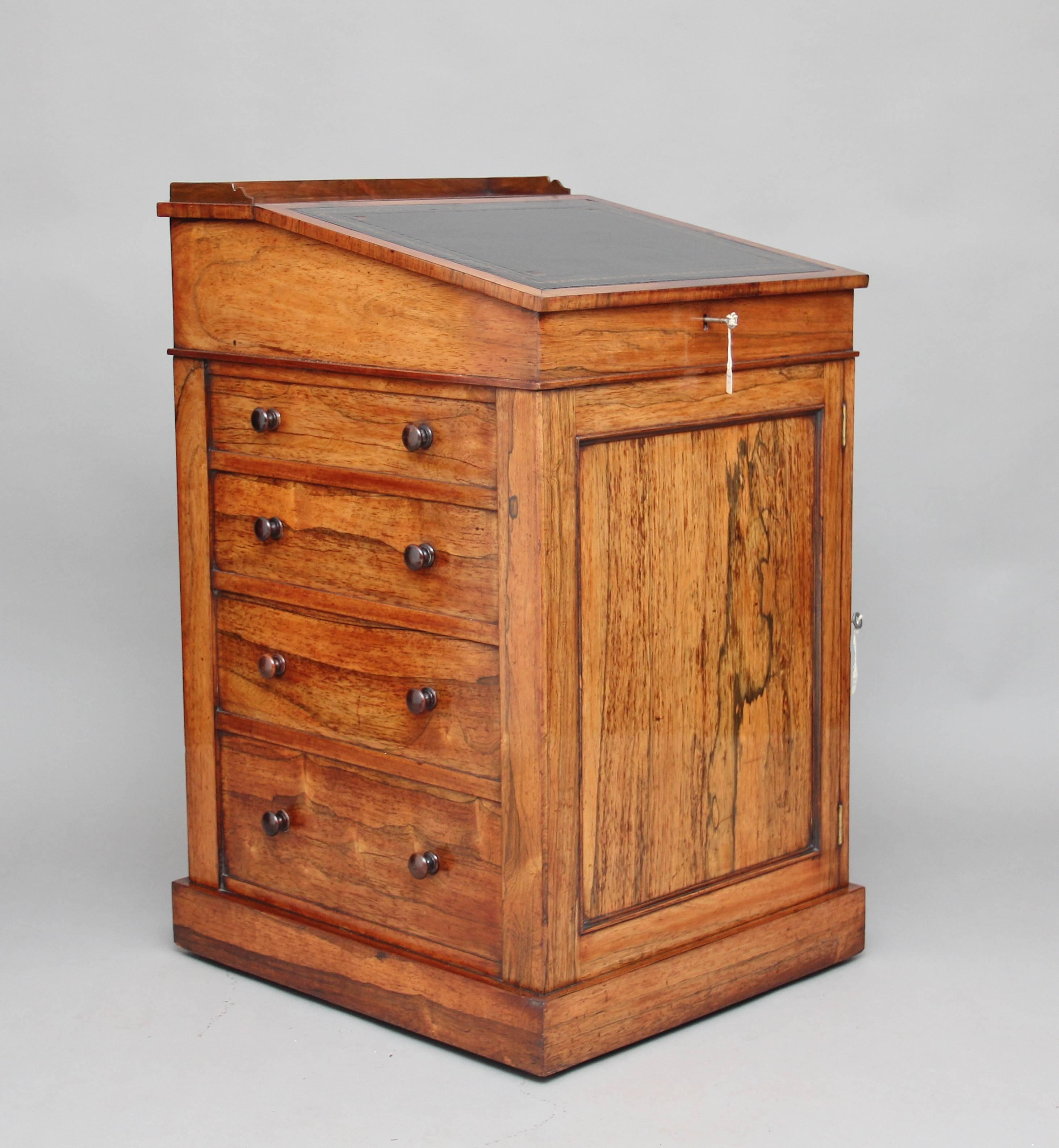 Early 19th century rosewood Davenport with four mahogany lined drawers on one side and four dummy drawers on the other side, above them it has a sloping top that slides forward to make it easier to sit and write at, the top has a black leather which