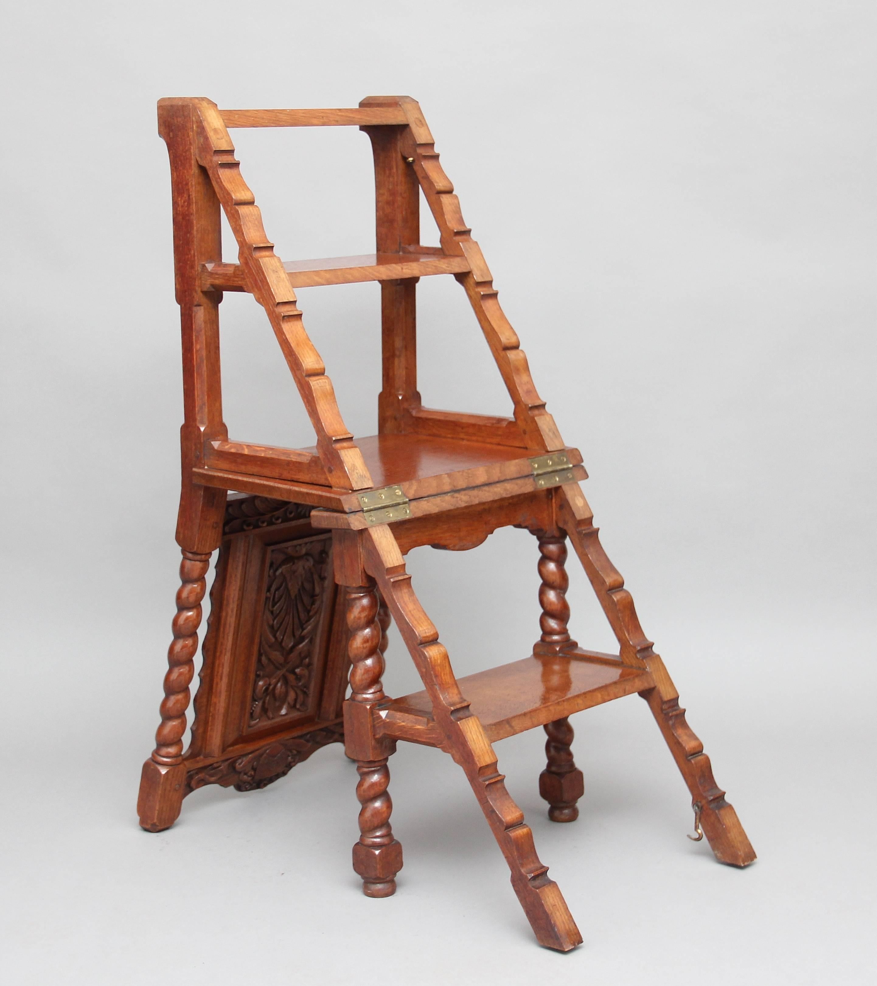 19th century oak metamorphic library step chair in the Victorian Gothic style, the chair having a well carved back incorporating a coat of arms and at the centre of the shaped back panel carved floral decoration, the step chair supported on barley