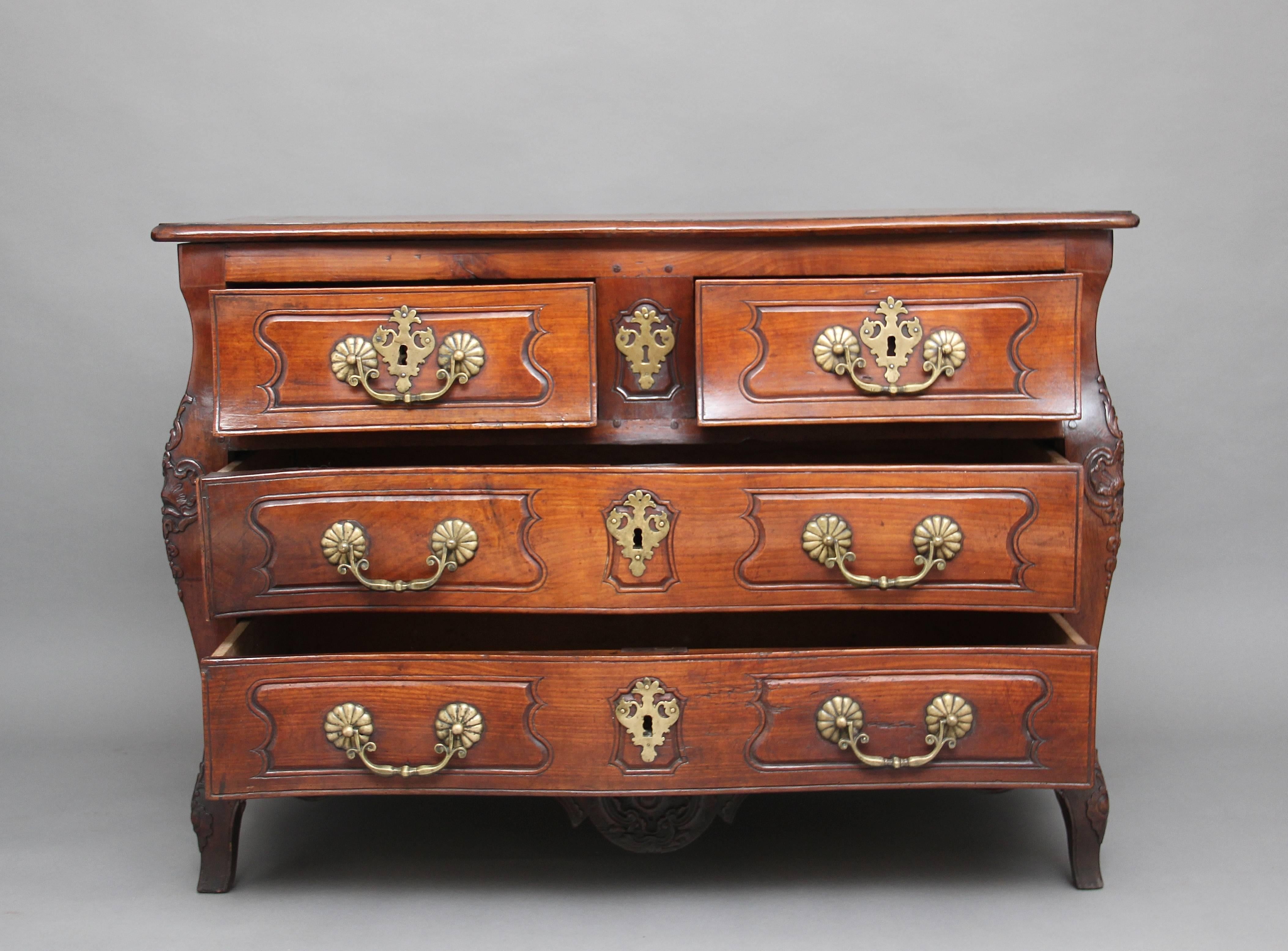 A superb quality 18th Century cherrywood commode of serpentine bombe form, with two small over two long drawers with original brass handles and escutcheons, original steel locks, with two shaped panel ends and carved decoration on the front, a