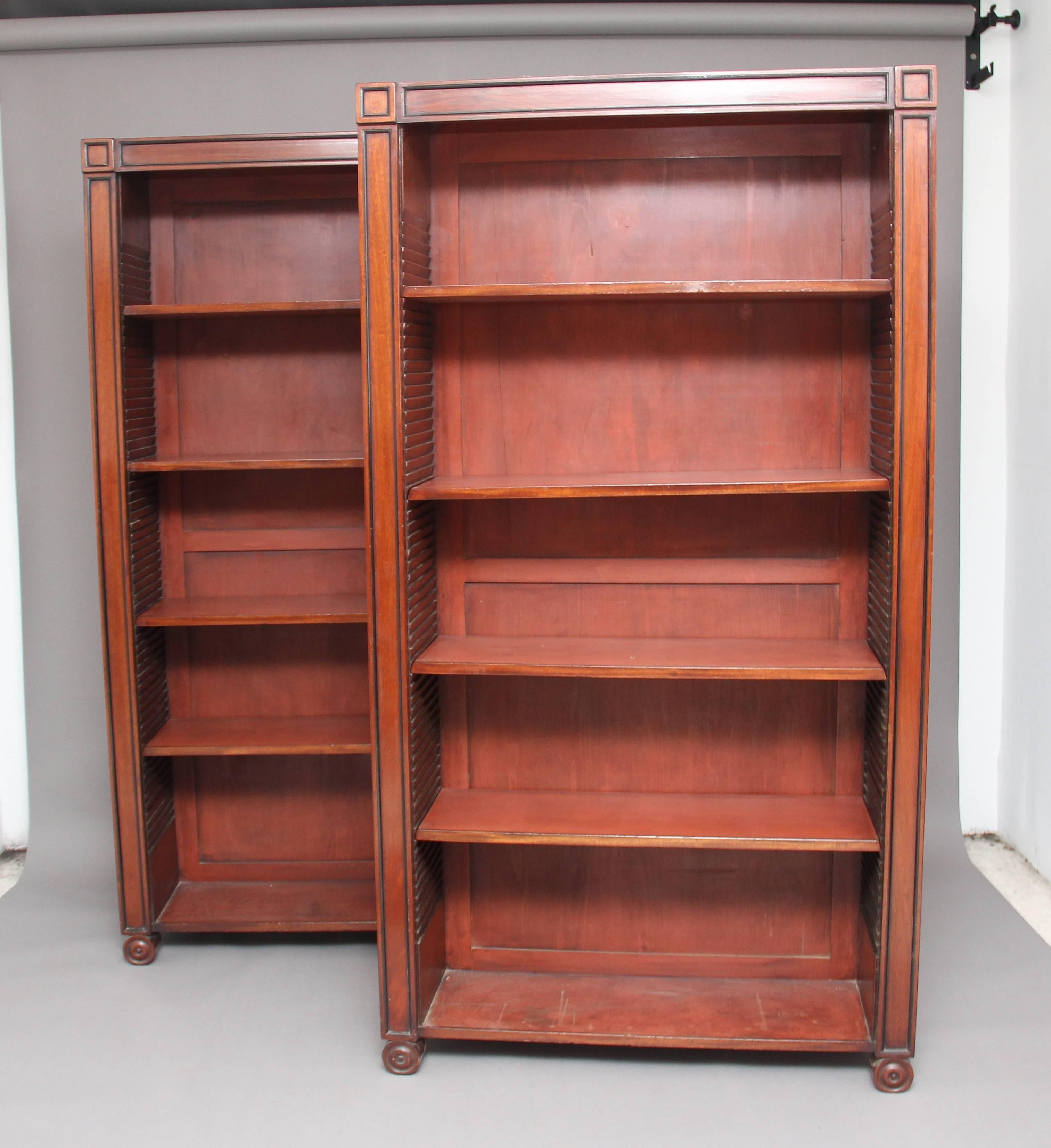 A nice pair of mid-20th century Regency style mahogany open bookcases, each bookcase having four adjustable shelves inside, decorated with ebonised moulded pilasters supported on scroll feet, circa 1960.
 