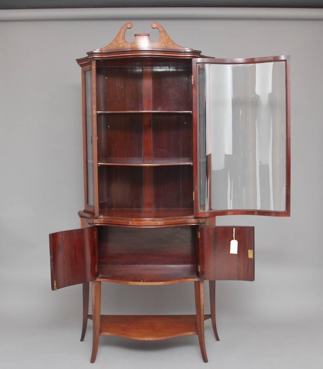 19th century mahogany Sheraton revival inlaid display cabinet possibly by Edwards & Roberts, profusely inlaid all over with floral marquetry, the inlaid broken arch pediment sitting in a moulded edge frieze, with a serpentine shaped single glazed