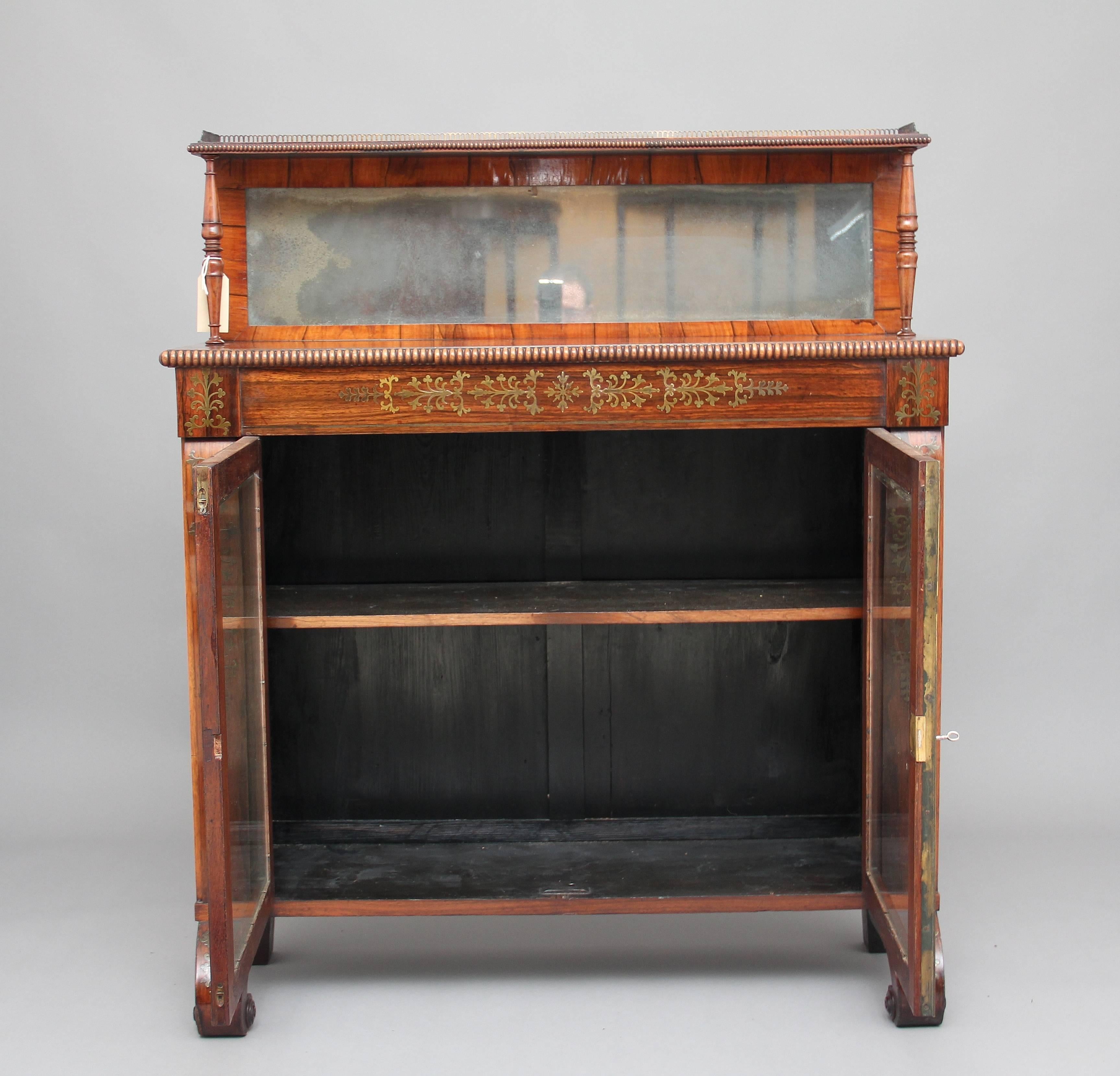 Early 19th century Regency rosewood and brass inlaid chiffonier, the cabinet having a mirror back and shelf decorated with beading and a brass gallery running along the front and sides, supported by elegant turned columns, the top of the actual