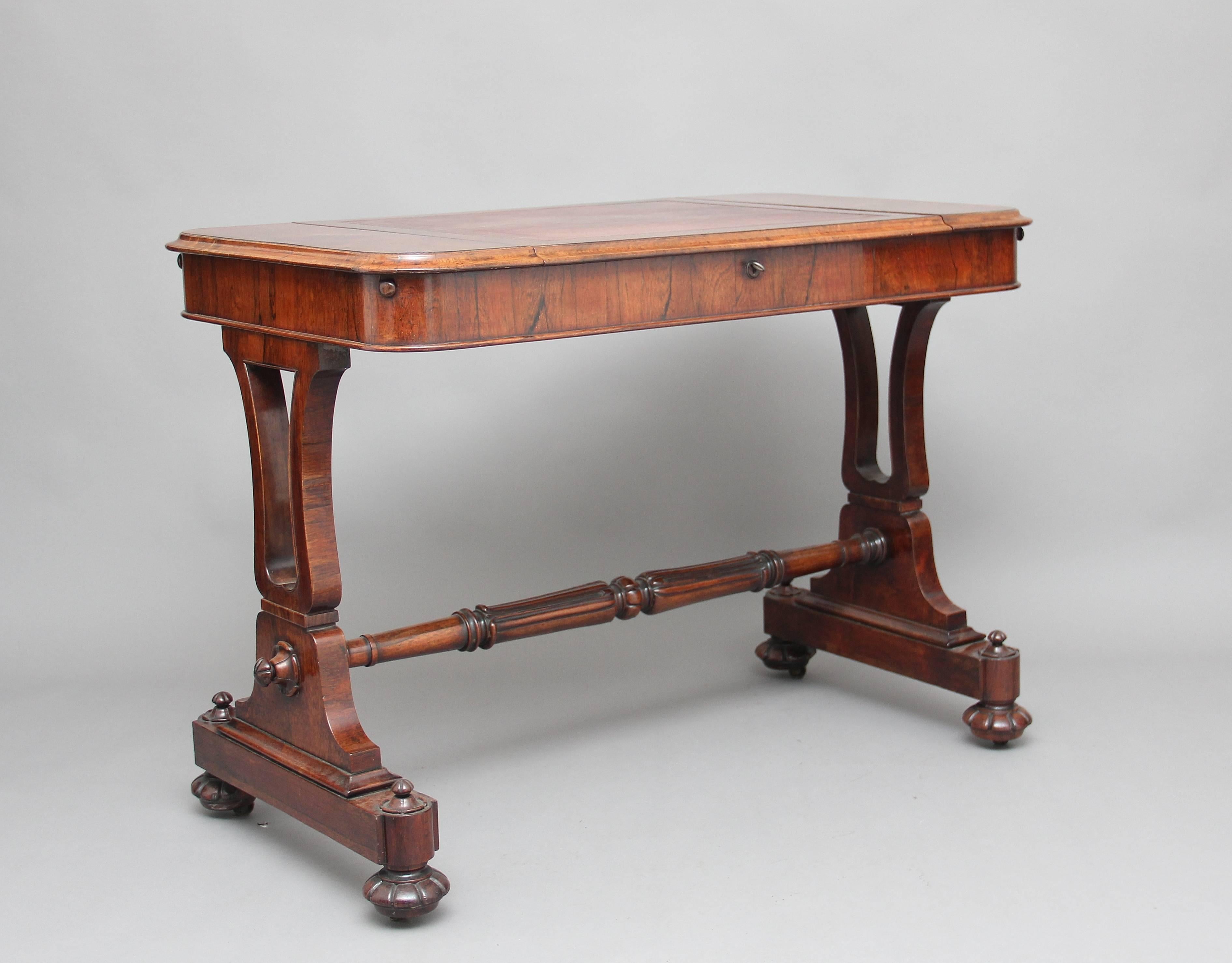 A very fine 19th century rosewood writing table in the style of Gillows, having a leather lined adjustable easel top with concealed end compartments, each with fitted interiors, on lyre end supports united by a lappet carved central stretcher on