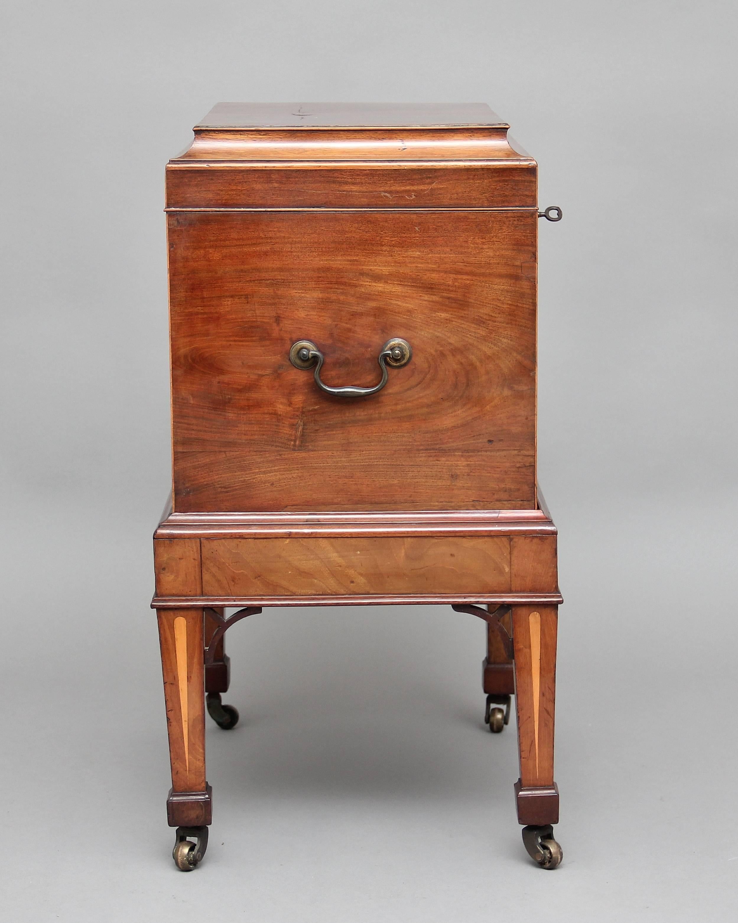 Early 19th century mahogany cellarette on stand with a nice shaped top opening to reveal a compartment for various bottles, standing on inlaid square tapering legs terminating with brass castors, circa 1820.
 