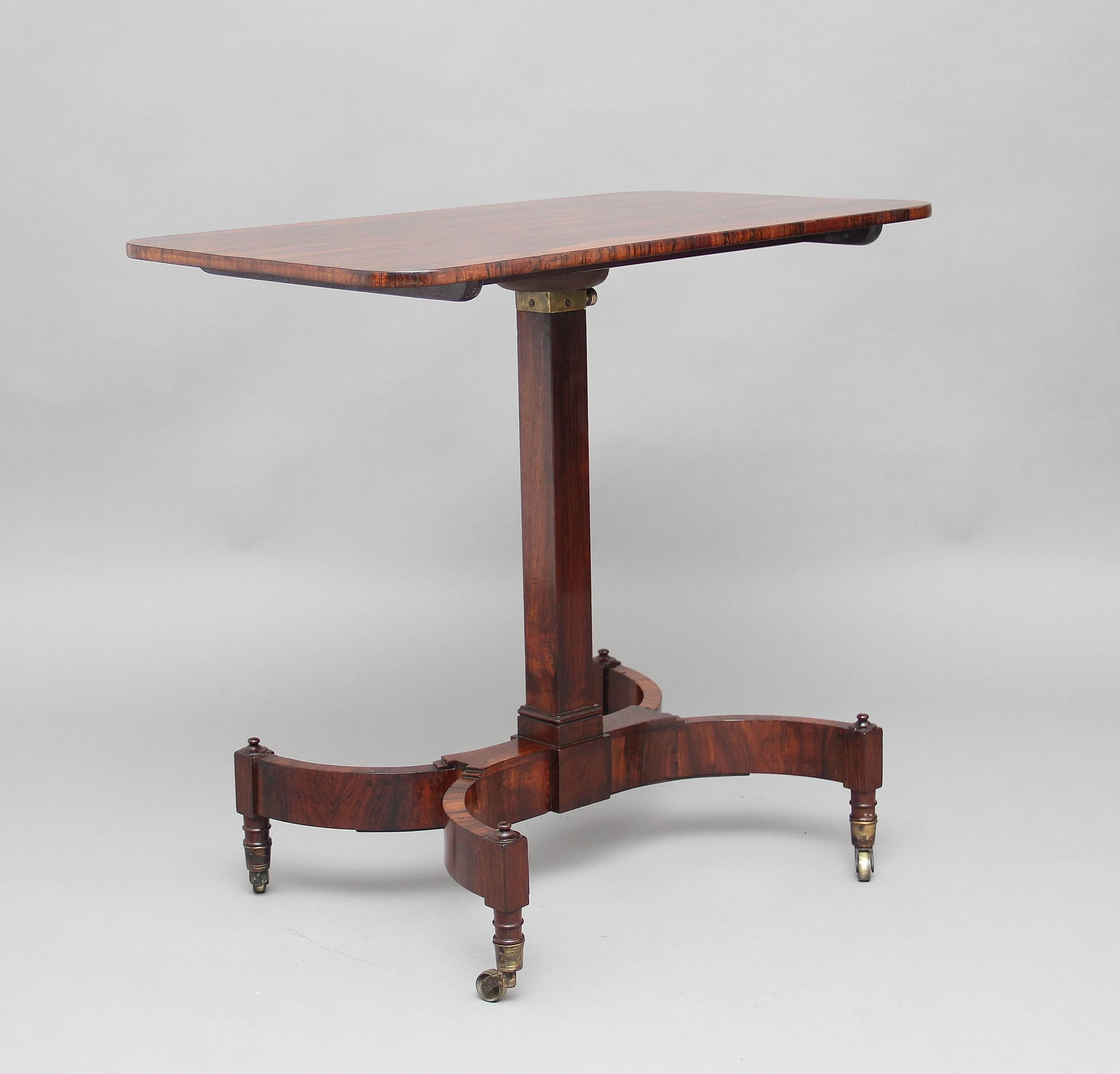 19th century Regency rosewood adjustable table, the rectangular top as well as being able to slide it has a rise and fall mechanism, supported on a square column ending on a shaped and swept base terminating with brass cap and castors, circa 1820.
 