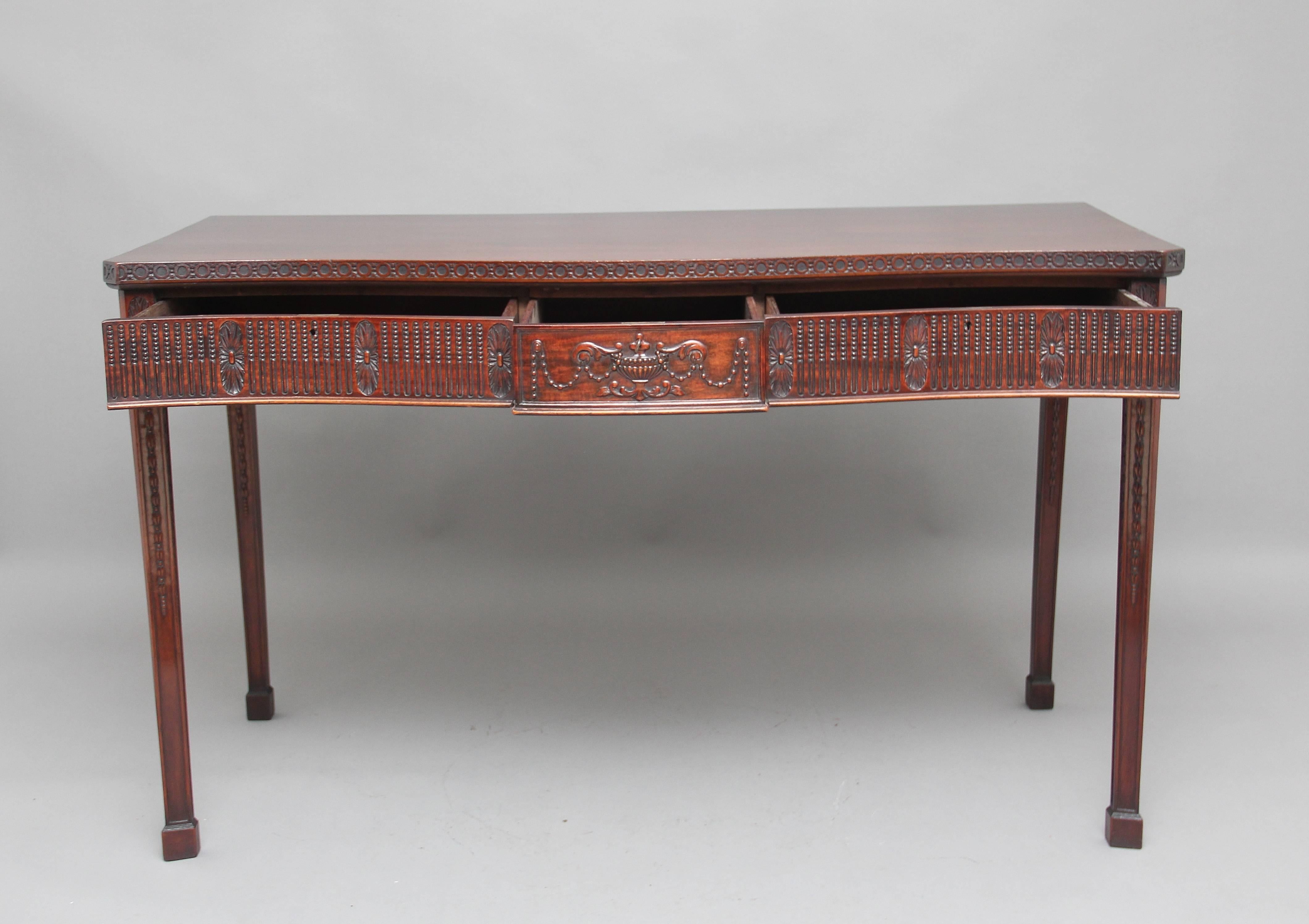 Early 20th century mahogany serpentine serving table in the 18th century style of Robert Adam, a fabulous quality piece of furniture with carving around the top and the frieze and down the legs, there are three drawers, the middle one decorated with