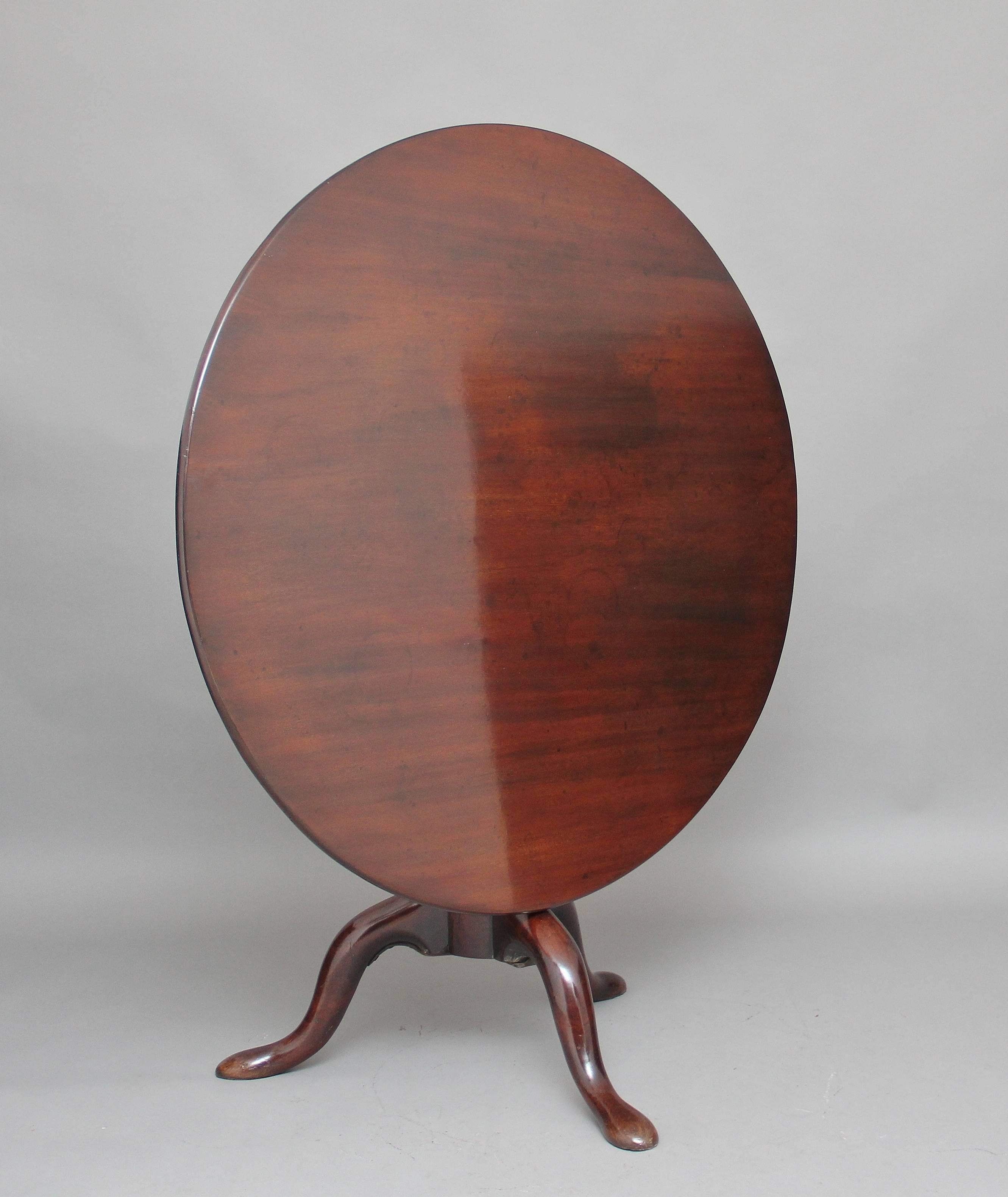 18th Century mahogany tripod table of large proportions, the circular mahogany top sitting on a birdcage mount so you can turn the top without turning the base, supported on a turned column terminating with three slender shaped legs.  Circa 1780.
