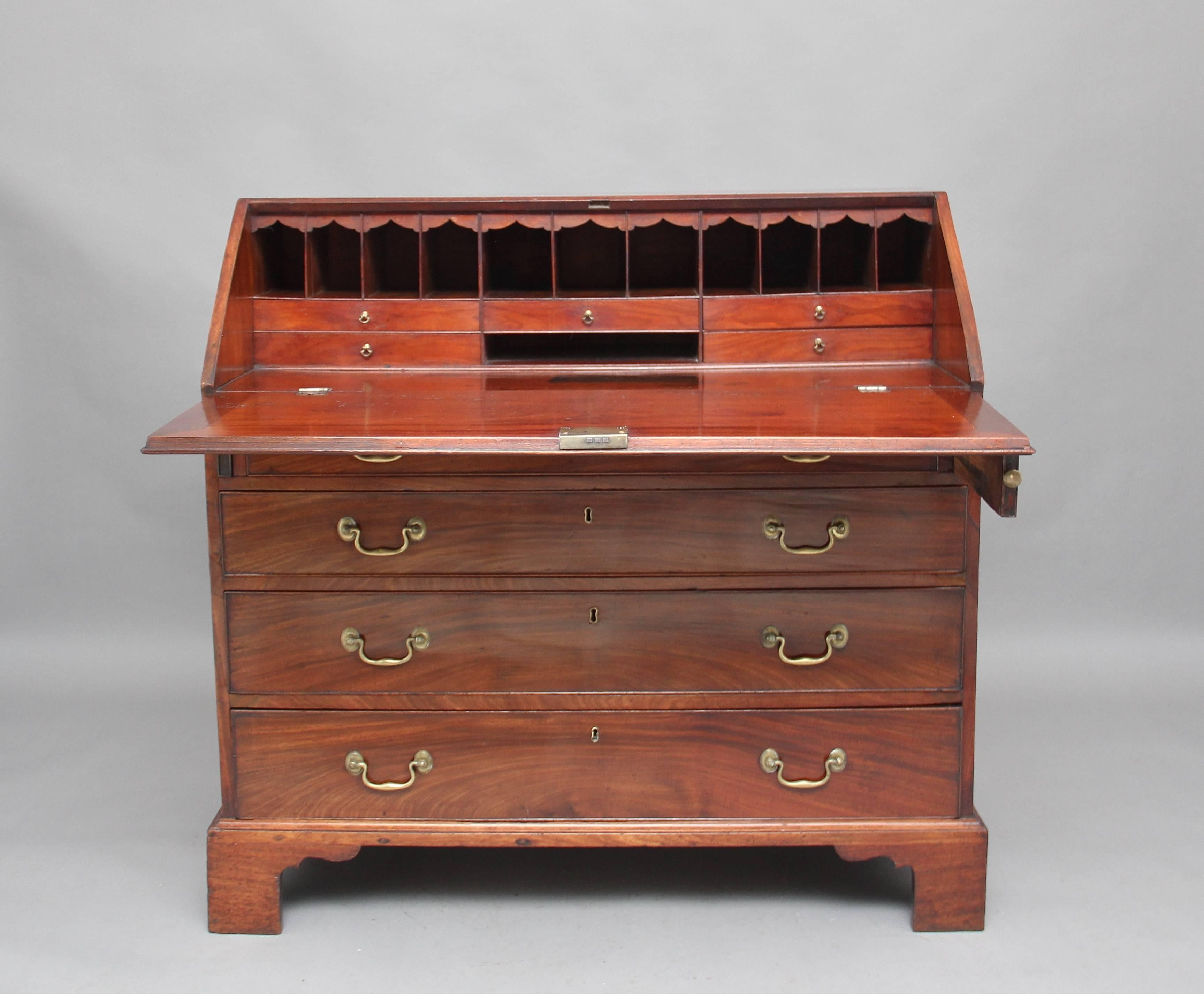 18th Century mahogany Georgian bureau, having a lovely fitted interior with various drawers and compartments, the bureau itself having four graduated oak lined drawers with original brass swan neck handles, standing on bracket feet.  Circa 1780.