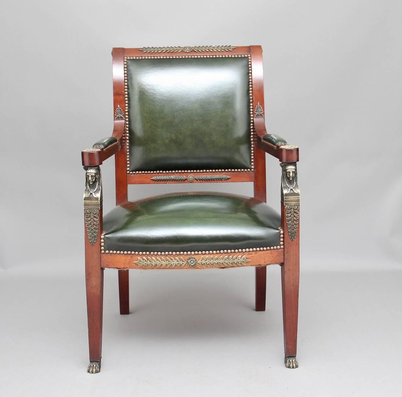 19th century French mahogany and ormolu open armchair upholstered in a dark green leather with brass stud decoration, the shaped and scroll back having patraes on either side, the leather padded arms terminating with larger patraes, the arms