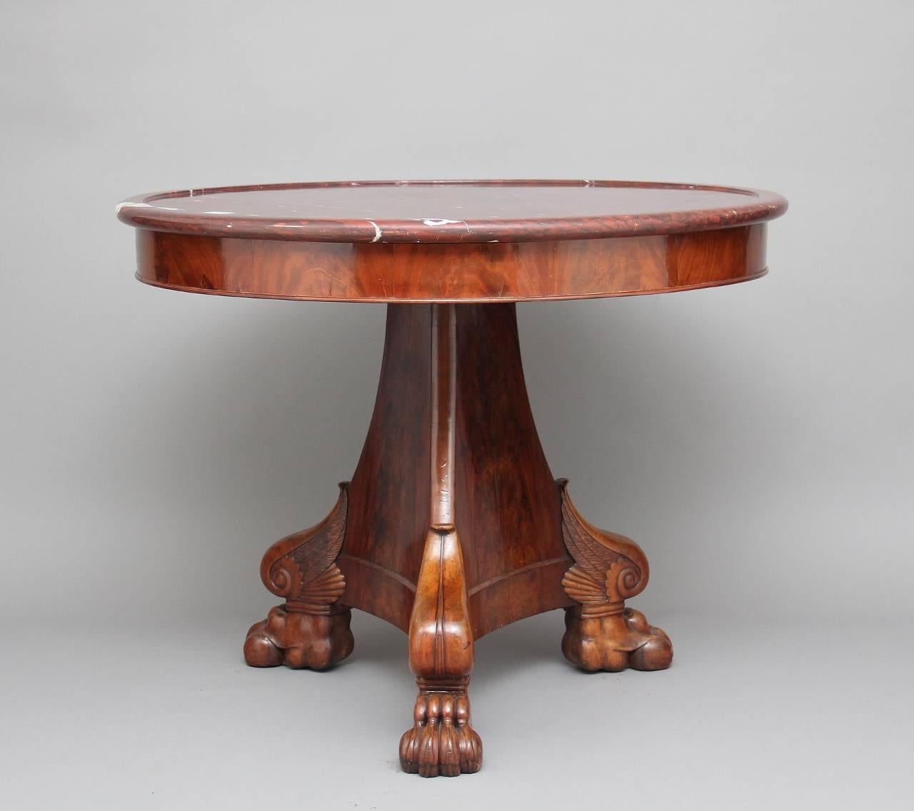 Early 19th century mahogany French gueridon / centre table with a rouge marble top with a moulded edge, the lovely shaped tri-form base supported on crisp carved claw feet with scroll and leaf decoration, circa 1820.
          