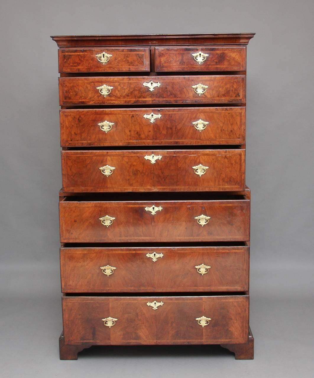 Early 18th century walnut chest on chest of good proportions, the moulded cornice above an arrangement of two short over six long graduated drawers with brass plate handles and escutcheons, the drawer fronts decorated with herringbone inlay,