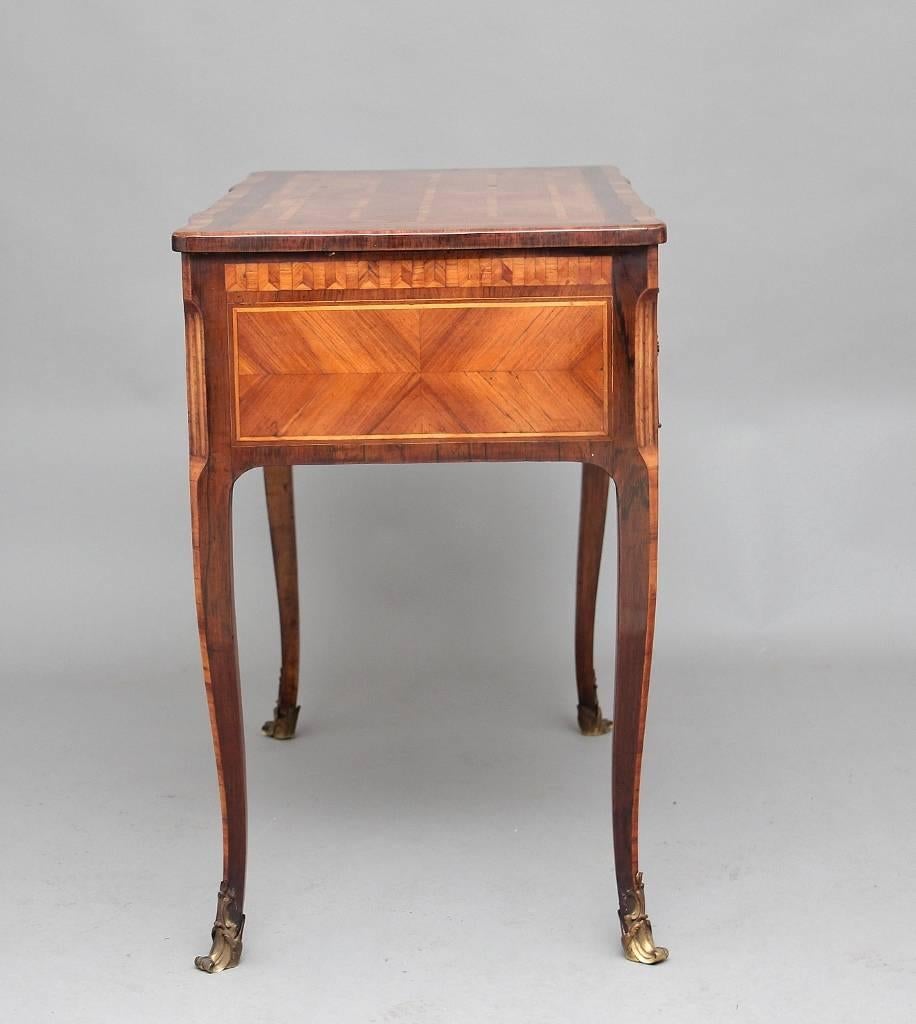 18th century French writing table veneered in tulipwood with rosewood and kingwood inlaid bandings, the rectangular shaped top with a parquetry design running round underneath, with a drawer at the centre and a pull-out leather lined writing slide