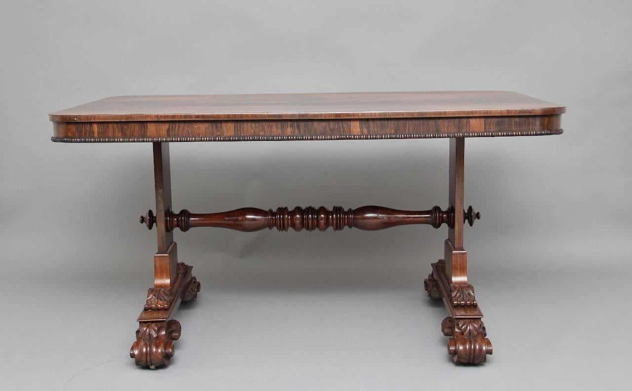 19th century rosewood library / sofa table, the rounded rectangular top with beading running along the bottom, above sofa end supports united by a wonderfully turned stretcher supported on foliate scrolling feet, circa 1840.