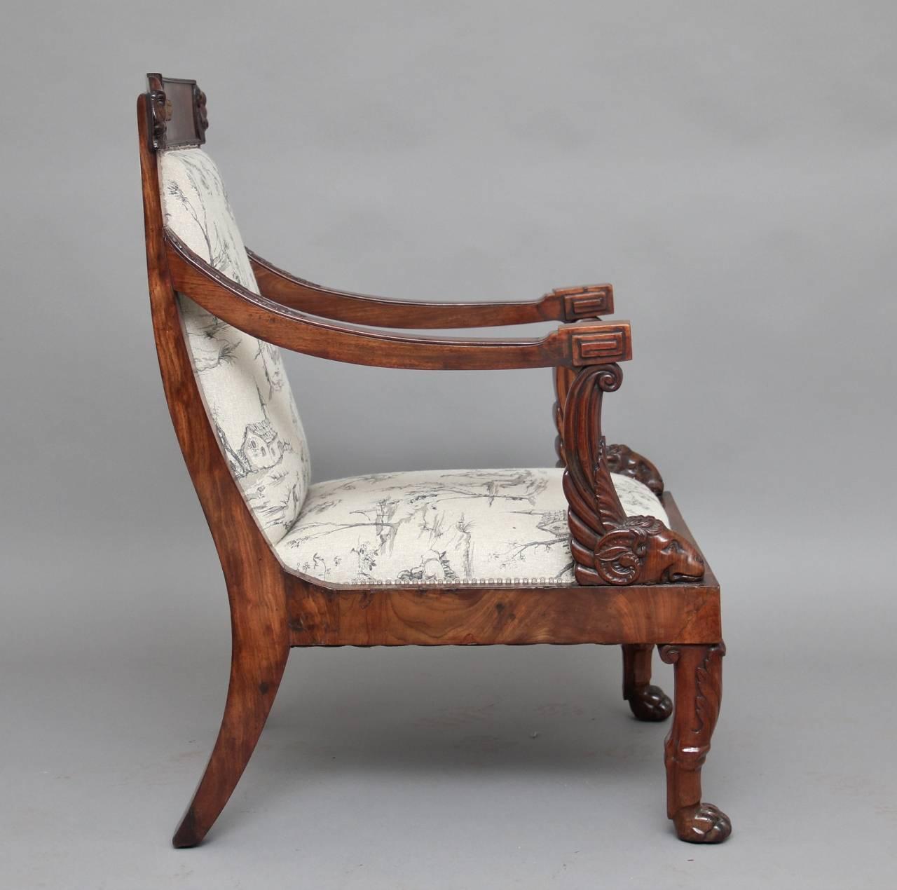 A lovely 19th century Regency mahogany open armchair, this well carved chair starts off with lions heads on the top curved rail, the shaped arms have acanthus leaf decoration and terminates with rams heads and the carved front legs ends in lions paw