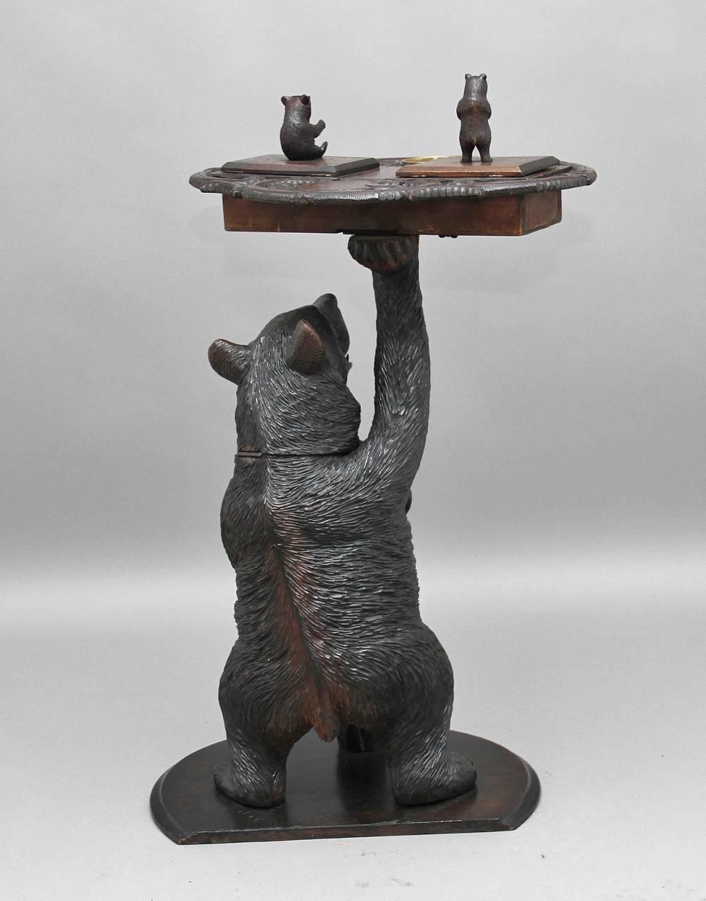 19th century musical Black Forest smokers stand, a fabulous quality item of a bear standing on a base leaning on a tree trunk, his other arm supporting a stylized tray with two small bears, one sitting on a lid which opens to reveal compartment, the
