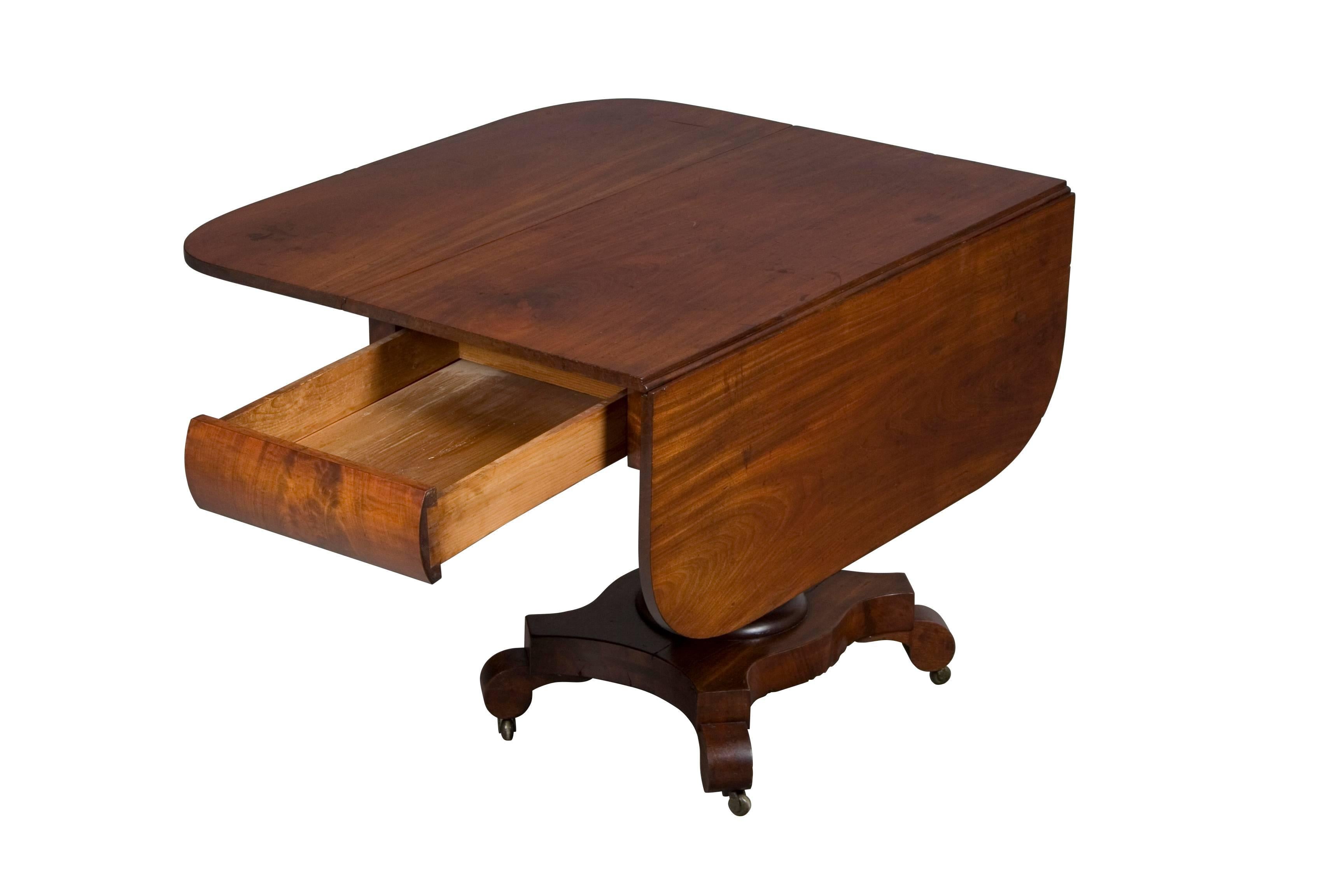 An English Victorian period antique (circa 1890), this drop-xx`leaf center table features a single drawer on one side and faux drawer on the other. It makes an excellent center table but would also do well as a small dining or breakfast table, game