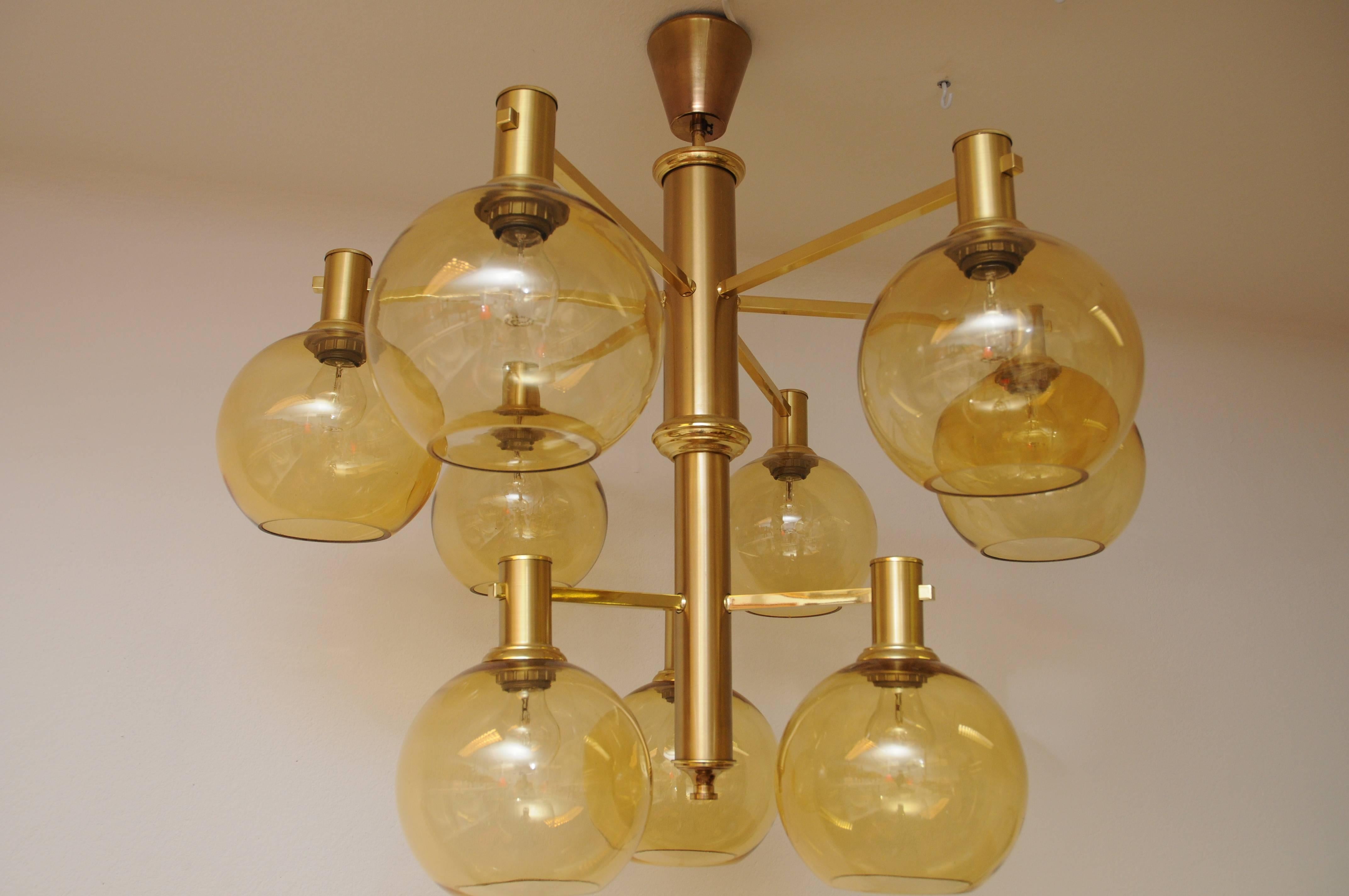 Big and massive ceiling lamp in the manner and style of Hans Agne Jakobsson. Brass pole and glass shades of  nine beautiful glass domes with golden shimmer on two separate floors. Probably produced in Sweden, circa 1960s. Beautiful in a livingroom
