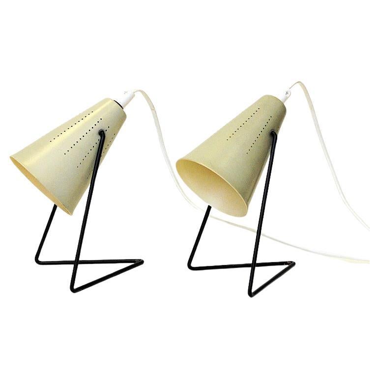 Lovely cream white enameled metal table lamp pair designed in 1955 by Svend Aage Holm Sørensen for Asea, Sweden. These cone shaped rare lamps can be adjusted in different directions, even straight up. Black metal L-shaped legs.
Unique design.
The