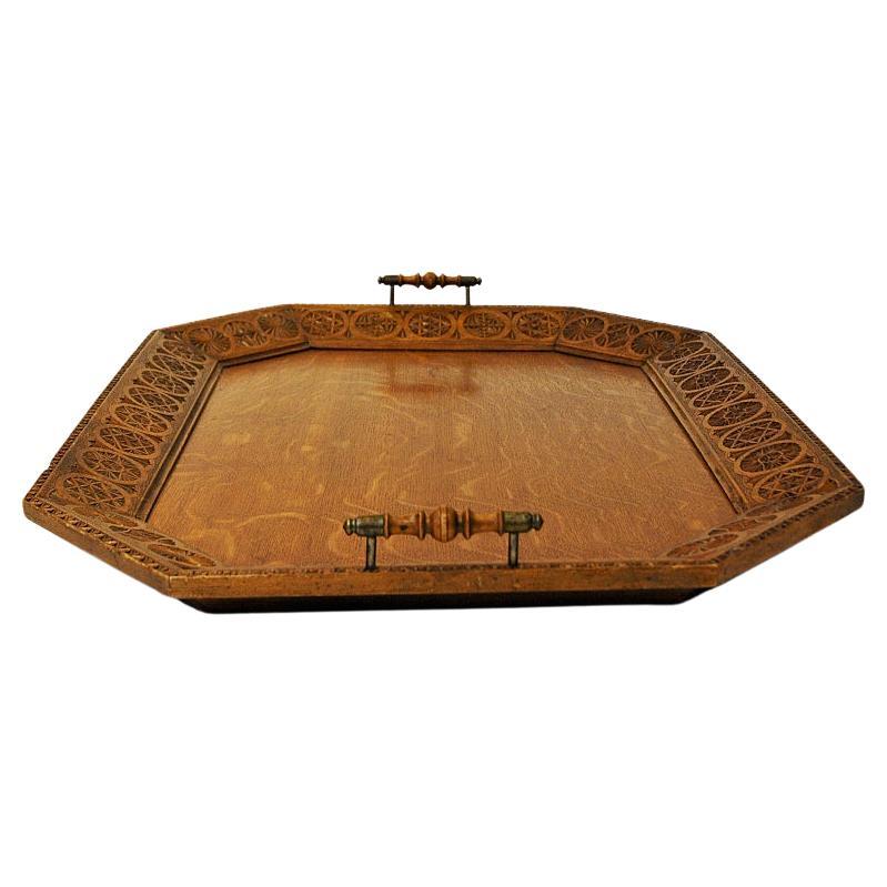 Beautiful and vintage rich carved wood serving plate from the 1920s Scandinavia. A fantastic large size tray with an octagon shape and wonderful handcarved edges all around. Decorated wood handles with metal details. Fixing on the back side which
